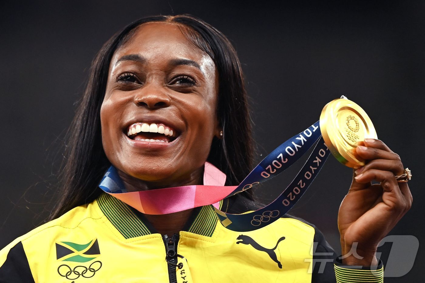 본문 이미지 - 도쿄 올림픽 육상 여자 200m에서 우승을 한 뒤 금메달을 들고 포즈를 취하고 있는 톰슨-헤라 ⓒ AFP=뉴스1