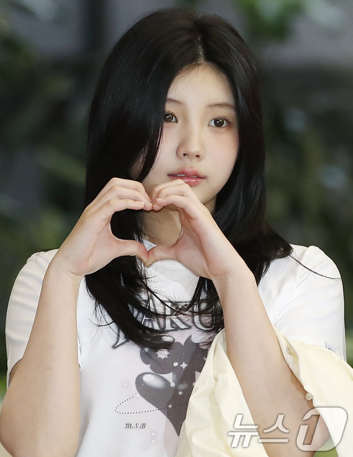 본문 이미지 - 아일릿 원희가 28일 해외 일정을 위해 김포공항에 도착해 일본으로 출국하기 전 하트를 그리고 있다. ⓒ News1 권현진 기자