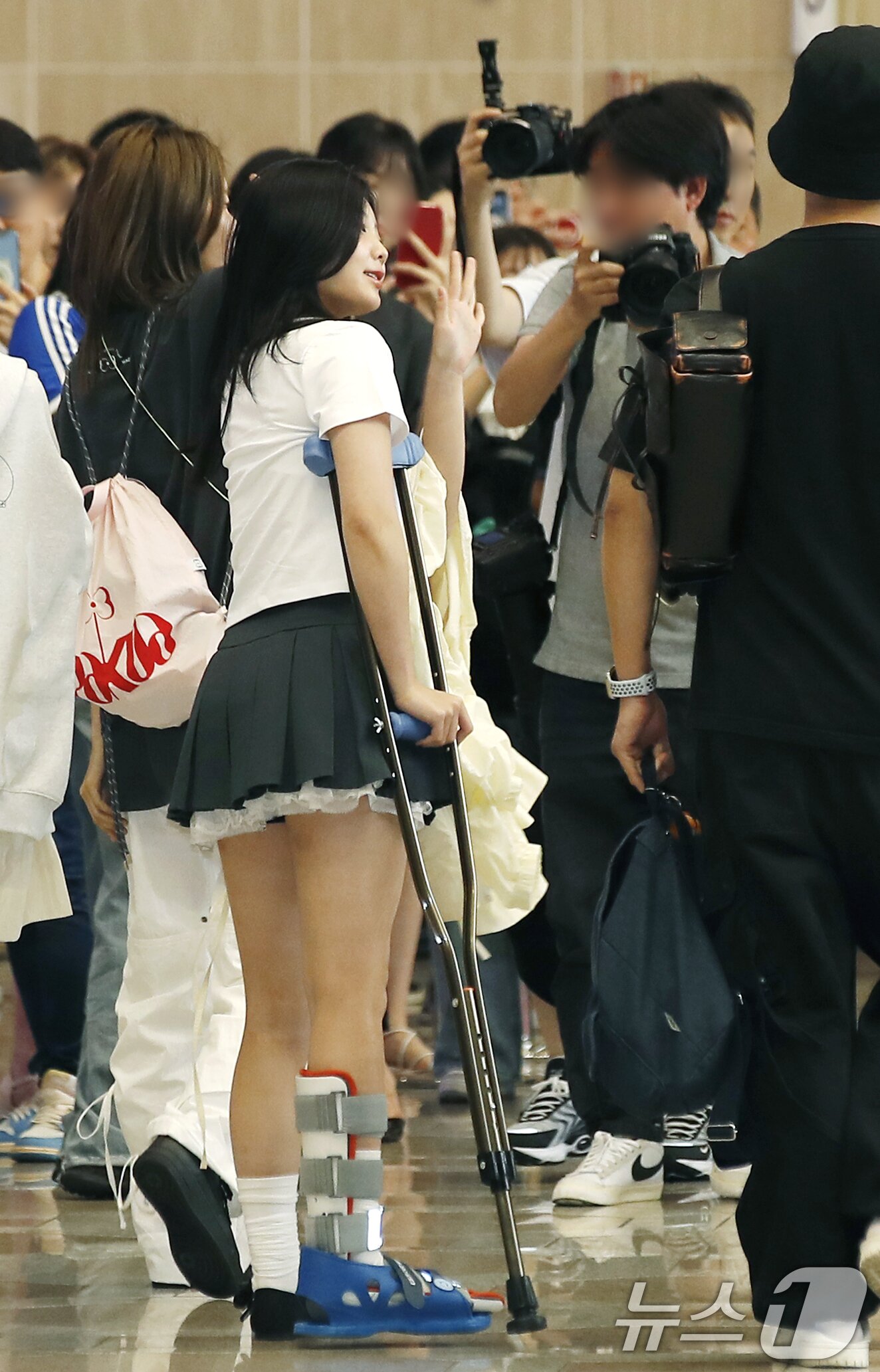 본문 이미지 - 아일릿 원희가 28일 일본 일정을 위해 김포공항에 도착해 자신의 부상을 걱정하는 팬에게 다정한 손 인사로 감사의 마음을 전하고 있다. ⓒ News1 권현진 기자