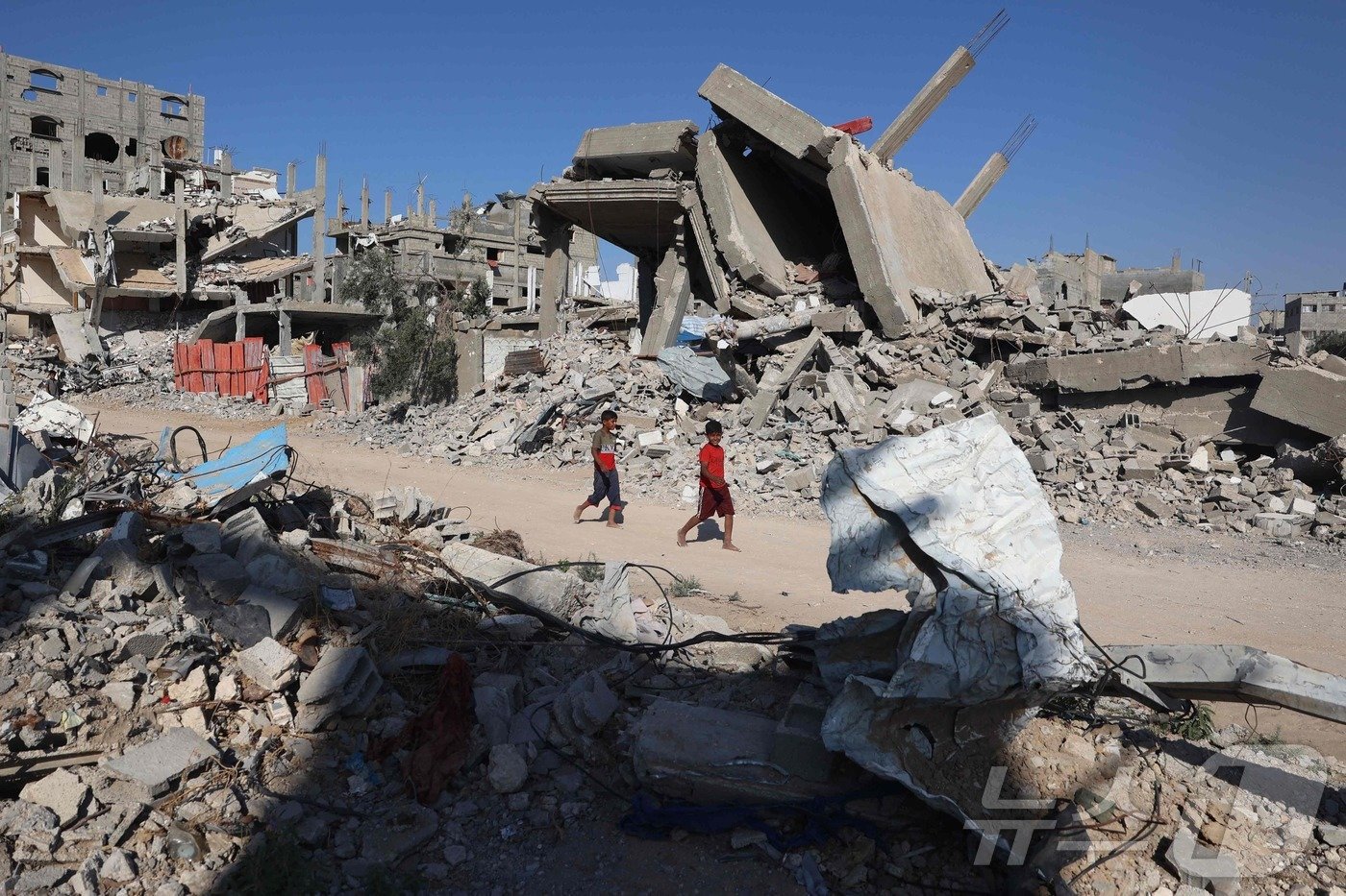 본문 이미지 - 피란민 천막이 집결한 가자지구 중부 알부레이 일대에 이스라엘군이 2일&#40;현지시간&#41; 포격을 가했다는 목격담이 전해진 가운데 이날 팔레스타인 소년들이 무너진 건물 잔해 옆을 걷고 있다. 2024.06.03. ⓒ AFP=뉴스1 ⓒ News1 김성식 기자