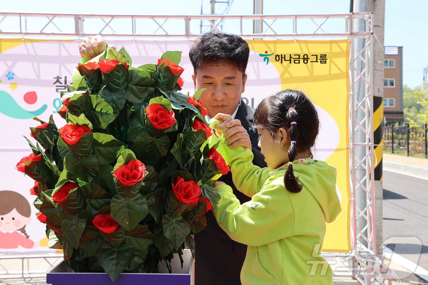 함영주 하나금융그룹 회장이 지난해 4월 경복 칠곡군 &#39;국공립 칠곡 왜관 하나 어린이집&#39; 개원식에서 왜관 하나 어린이집 원아와 화분에 물을 주고 있다.&#40;하나금융그룹 제공&#41;