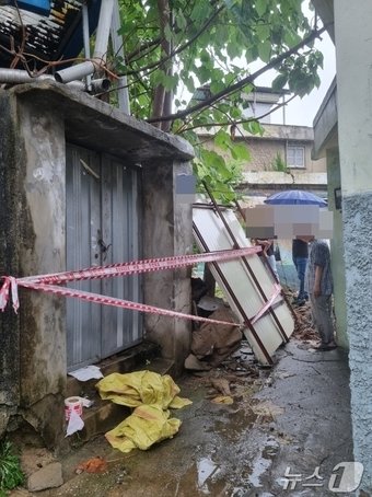 본문 이미지 - 지난달 30일 오전 8시쯤 광주의 장맛비에 한 빈집 담장이 무너졌다는 신고가 접수돼 행정당국이 안전조치를 취하고 있다.(광주 남구 제공) 2024.6.30/뉴스1