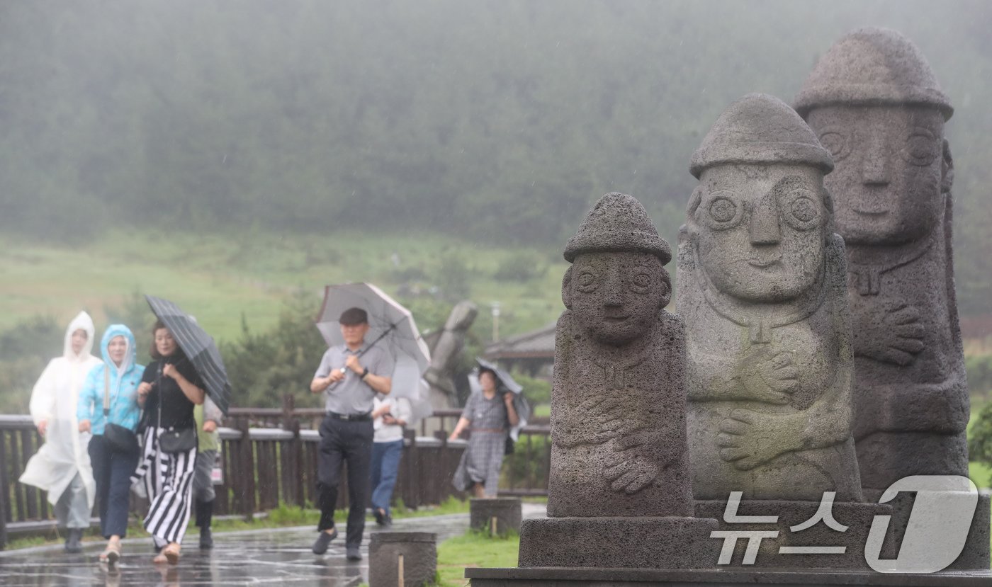 본문 이미지 - 제주에 이틀째 거센 장맛비와 함께 강풍이 몰아치는 30일 오전 서귀포시 대정읍 송악산 둘레길에서 관광객들이 우산을 쓰고 이동하고 있다. 2024.6.30/뉴스1 ⓒ News1 오현지 기자
