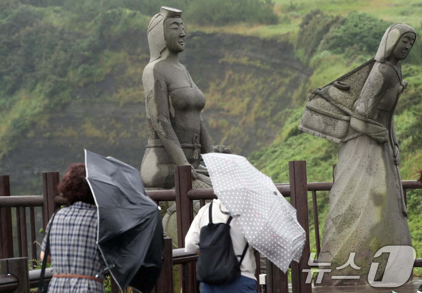 본문 이미지 - 제주에 이틀째 거센 장맛비와 함께 강풍이 몰아치는 30일 오전 서귀포시 대정읍 송악산 둘레길에서 관광객들이 우산을 쓰고 이동하고 있다. 2024.6.30/뉴스1 ⓒ News1 오현지 기자