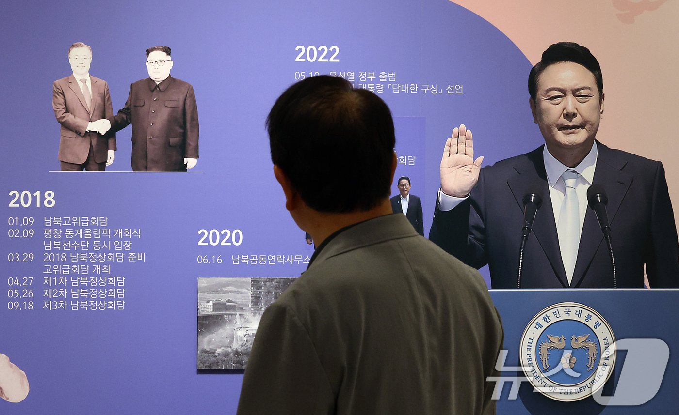 본문 이미지 - 4일 경기도 파주시 오두산 통일전망대를 찾은 관람객이 상설전시실 내 문재인 전 대통령과 북한 김정은 북한 노동당 총비서의 지난 2018년 남북정상회담 사진과 윤석열 대통령의 취임 선서 사진을 바라보고 있다. 2024.6.4/뉴스1 ⓒ News1 박정호 기자