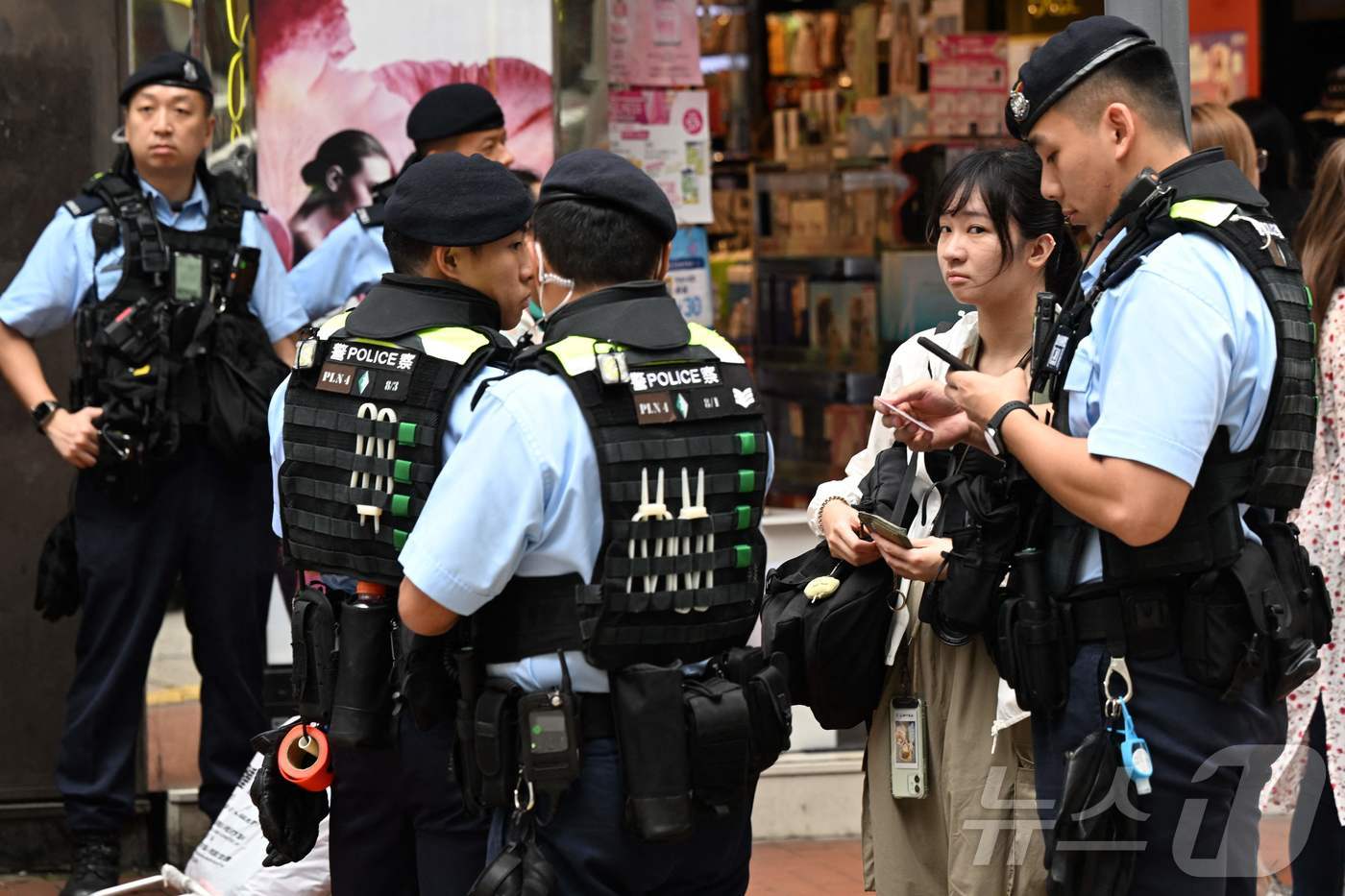 (AFP=뉴스1) 조소영 기자 = '천안문 사태' 35주기를 맞은 4일 홍콩 코즈웨이 베이 지역의 한 거리에서 홍콩 경찰이 한 여성을 검문하고 있다. 2024.06.04/뉴스1ⓒ …