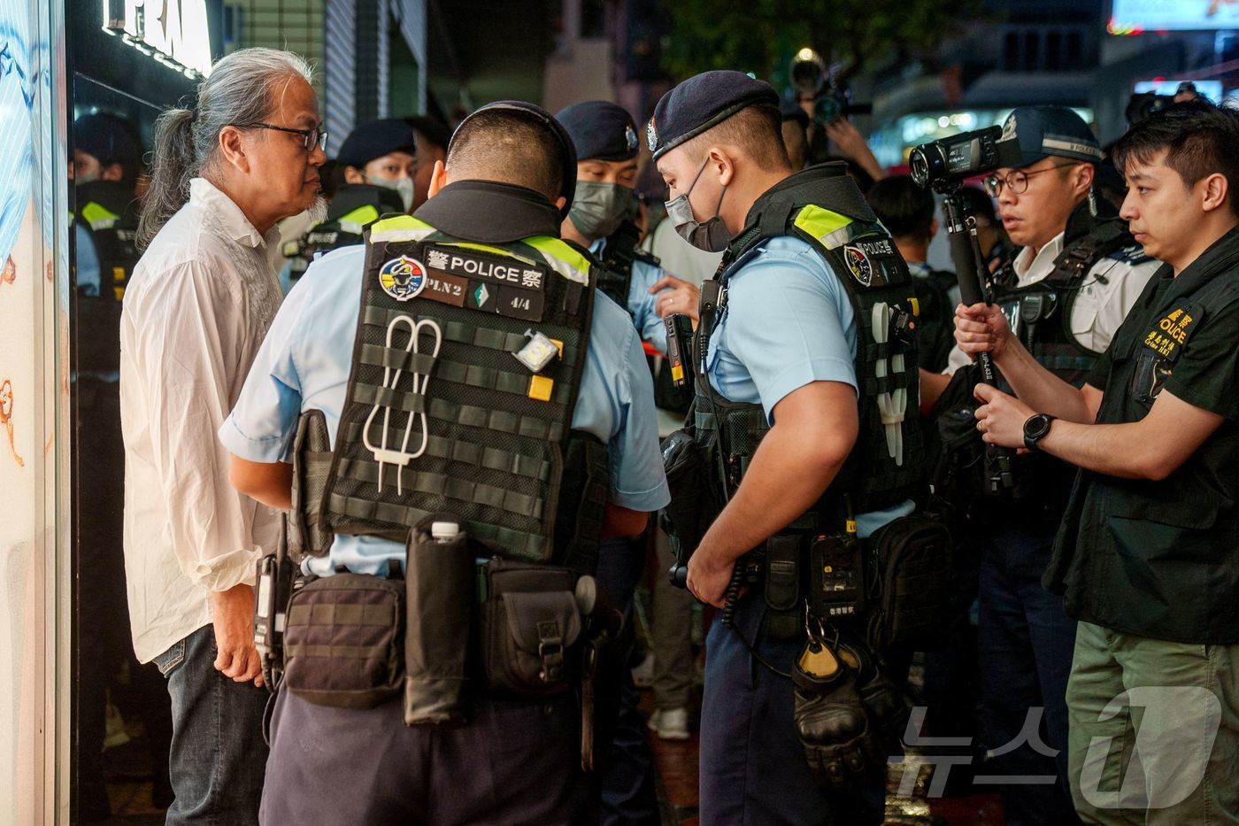 (홍콩 AFP=뉴스1) 권진영 기자 = 3일(현지시간) 홍콩 코즈웨이 베이 인근에서 경찰이 톈안먼 사태를 상징하는 손짓을 한 시민을 수색하고 있다. 2024.06.03/ⓒ AFP= …