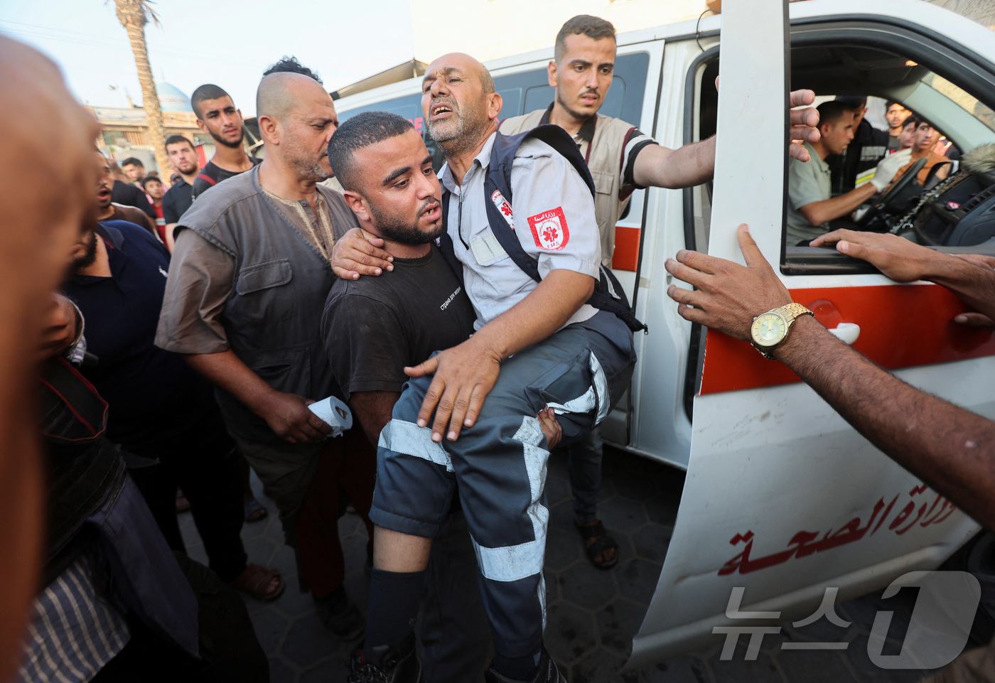(데이르알발라 로이터=뉴스1) 권진영 기자 = 4일(현지시간) 가자지구 중부 데이르 알-발라에서 한 남성이 이스라엘의 공격으로 부상을 입은 구급대원을 안고 이동하고 있다. 2024 …