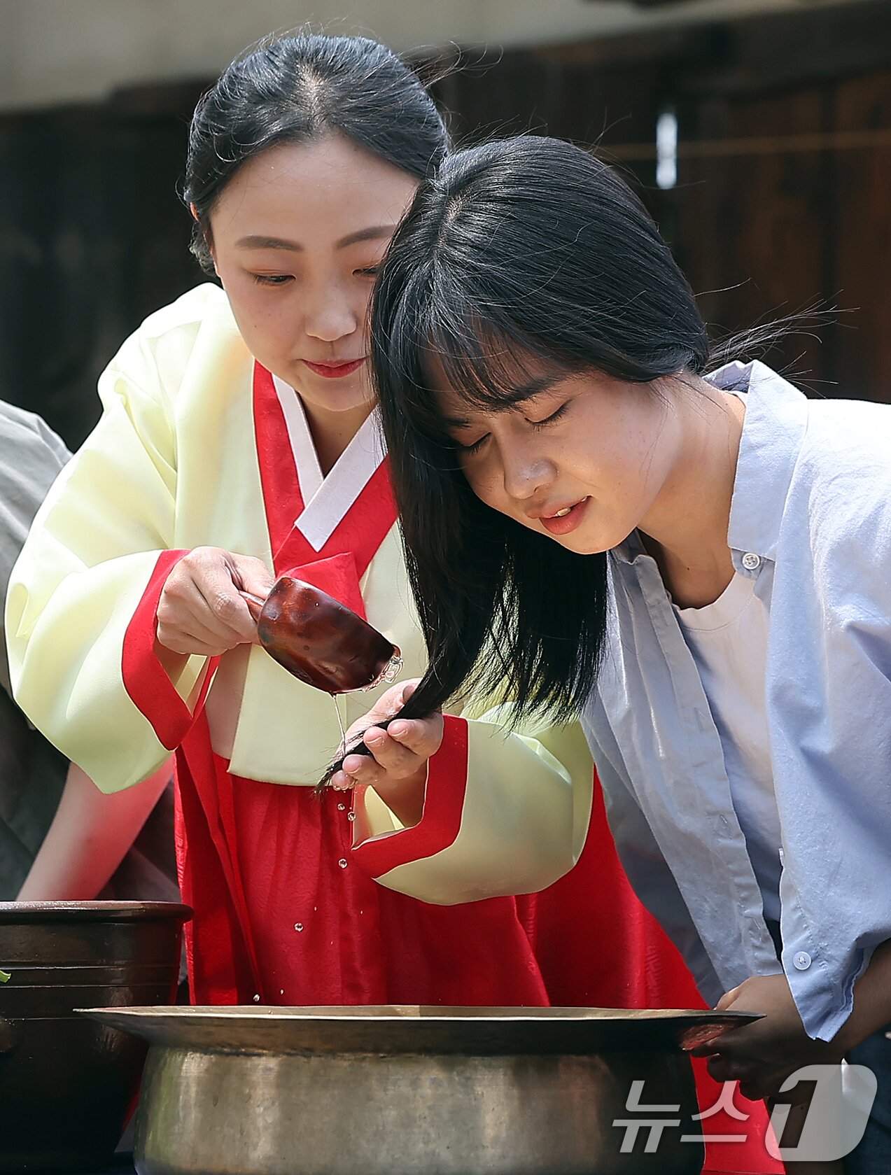 본문 이미지 - 절기상 단오(음력 5월 5일)를 닷새 앞둔 5일 오후 서울 종로구 국립민속박물관 오촌댁에서 외국인 관광객이 창포물에 머리 감기 체험을 하고 있다. 2024.6.5/뉴스1 ⓒ News1 김진환 기자