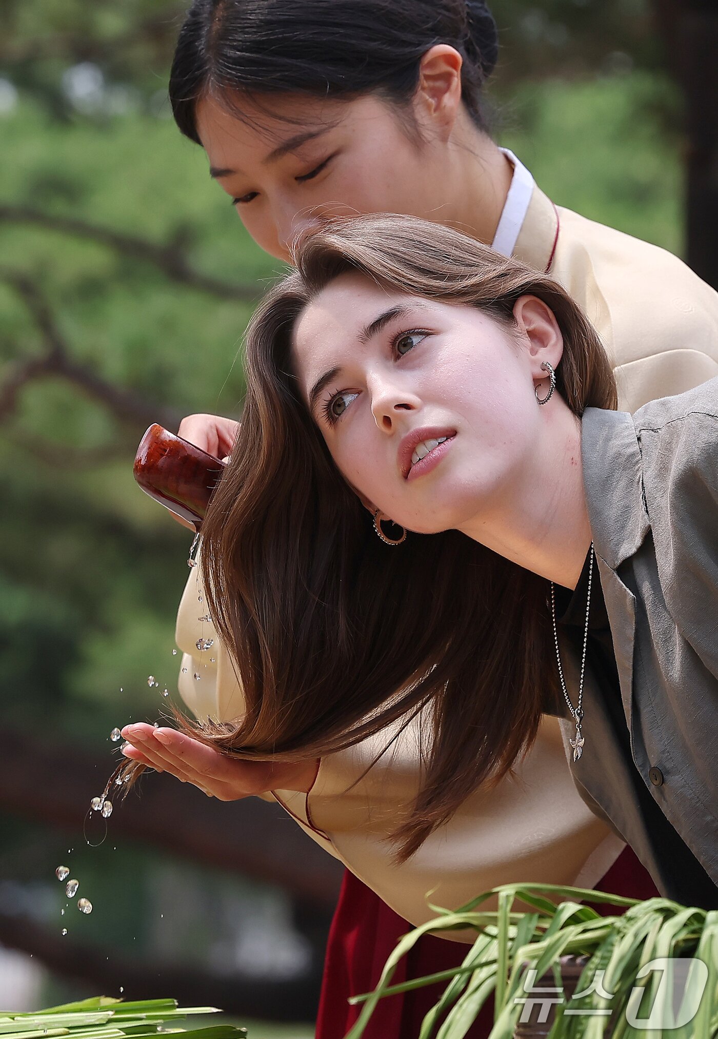 본문 이미지 - 절기상 단오(음력 5월 5일)를 닷새 앞둔 5일 오후 서울 종로구 국립민속박물관 오촌댁에서 외국인 관광객이 창포물에 머리 감기 체험을 하고 있다. 2024.6.5/뉴스1 ⓒ News1 김진환 기자
