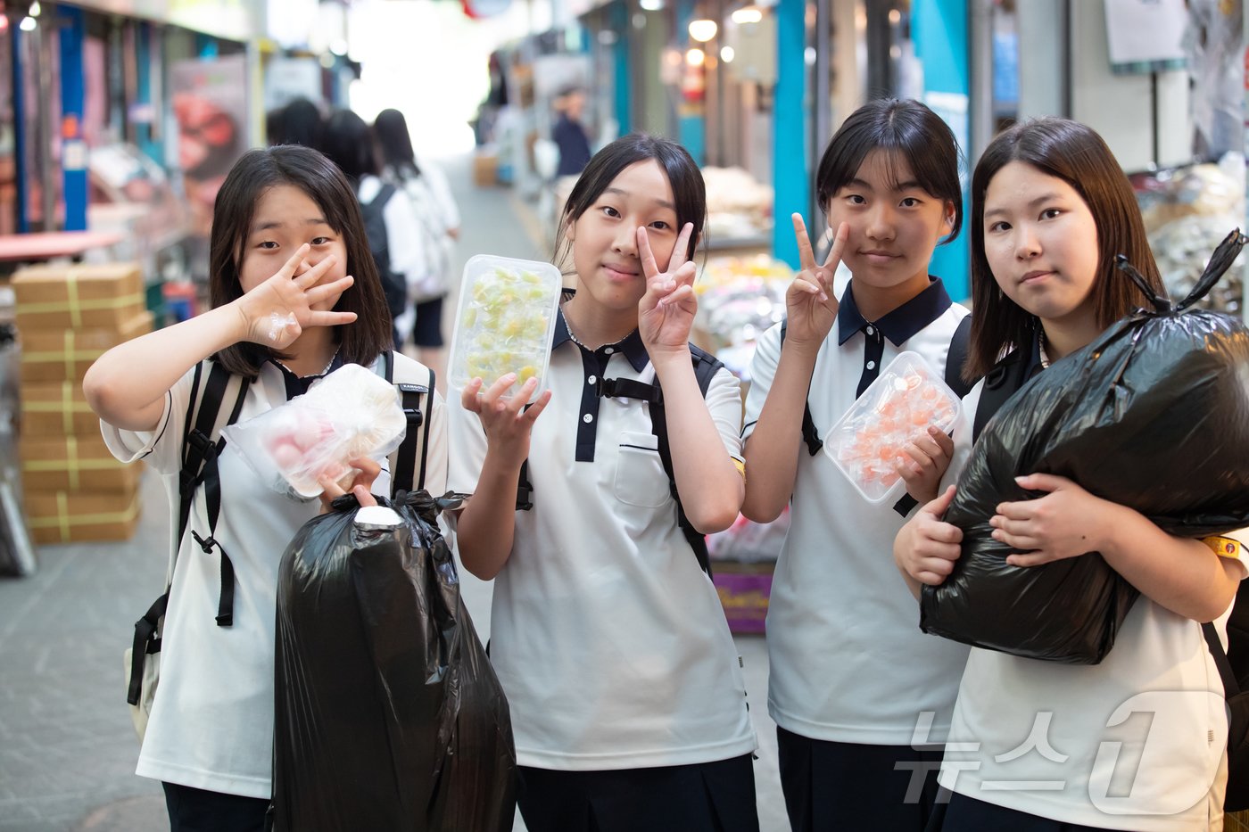 본문 이미지 - 광주시교육청의 전통시장 체험교육에 참여한 광주 수피아여중 학생들이 주어진 온누리상품권 1만원으로 구매한 간식거리를 한 아름 안고 있다.(광주시교육청 제공)2024.6.5./뉴스1