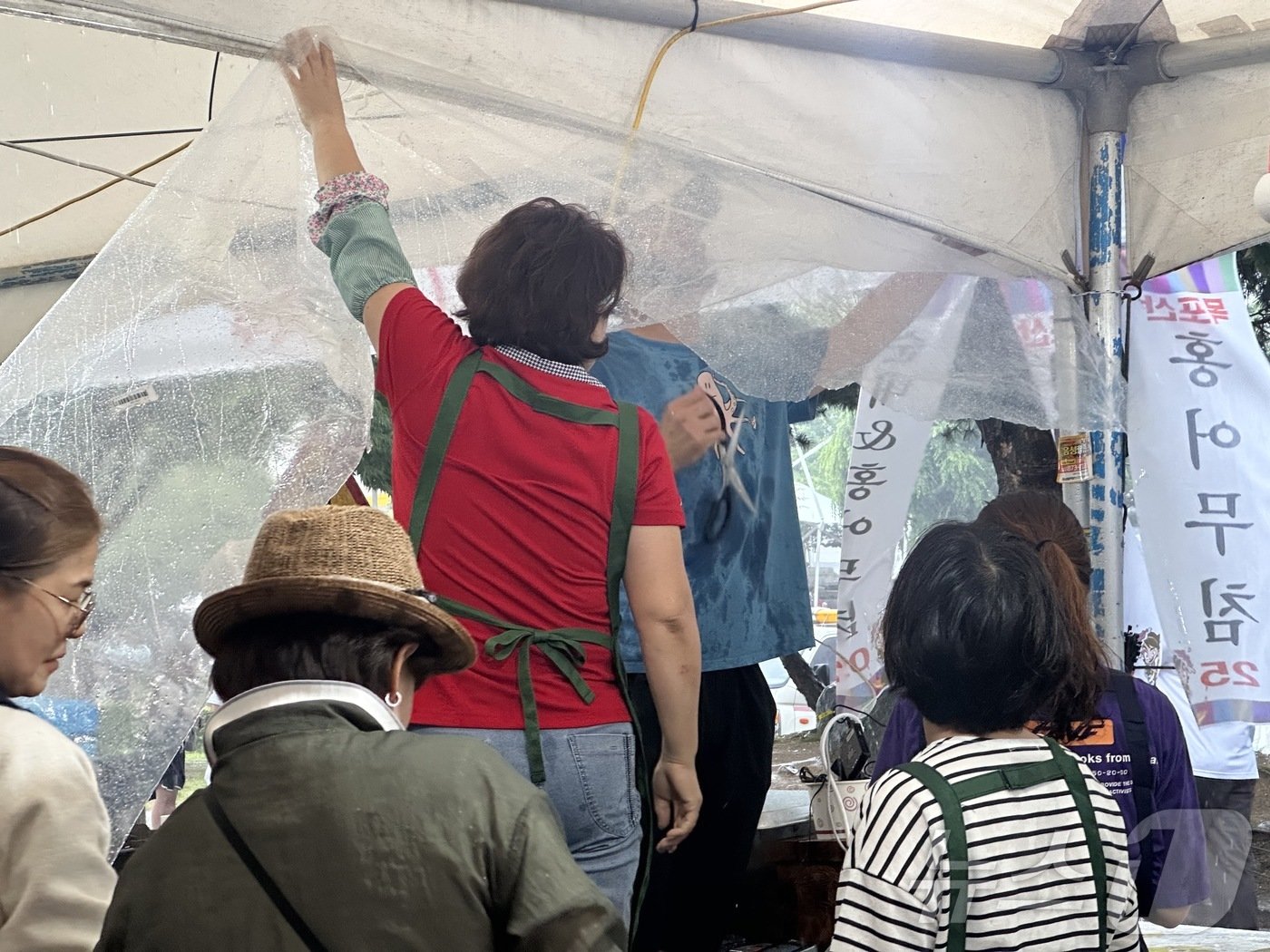  폭우에 급하게 천막을 보수하고 있는 음식점 상인들ⓒ 뉴스1 윤슬빈 기자