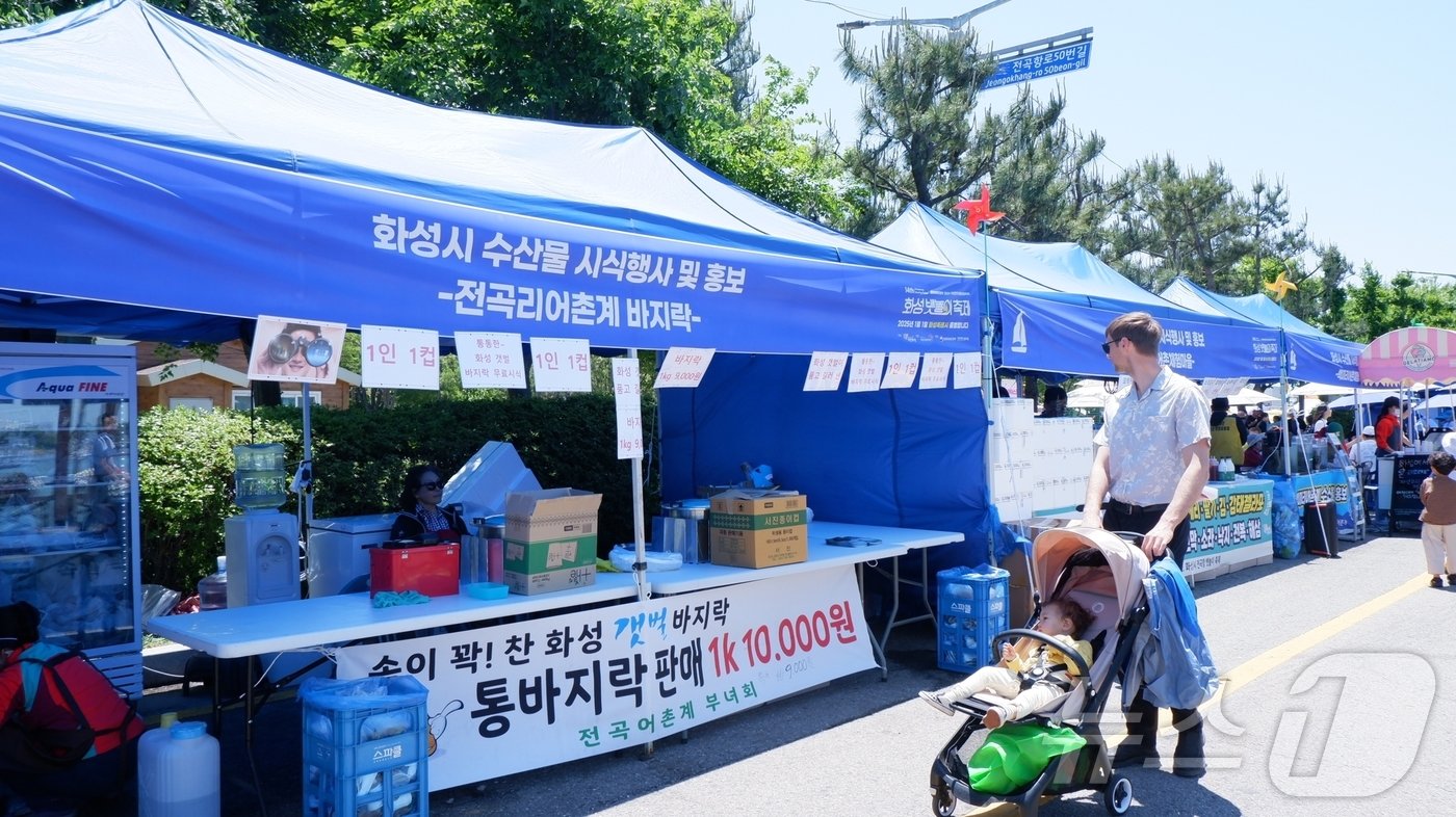  수산물을 비롯해 화성시 수산물을 시식하고 홍보하는 부스를 구경하고 있는 외국인 관광객의 모습ⓒ 뉴스1 윤슬빈 기자