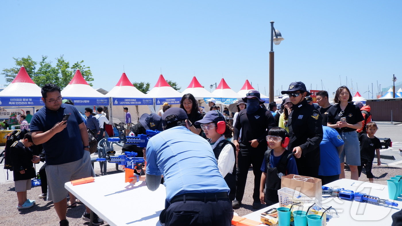 본문 이미지 -  해양경찰관과 함께 사격 체험 중인 어린이들ⓒ 뉴스1 윤슬빈 기자