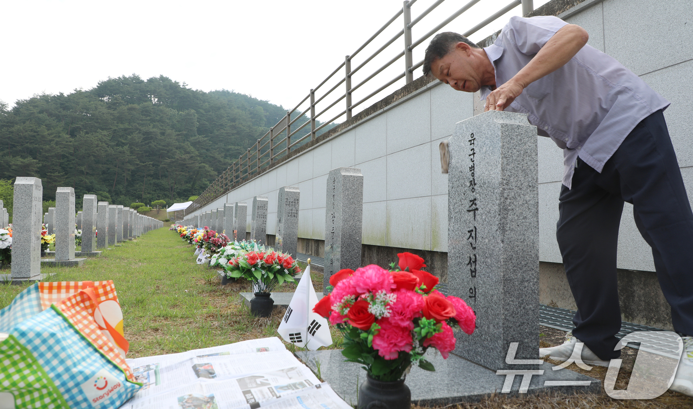 (임실=뉴스1) 유경석 기자 = 현충일인 6일 전북자치도 임실군 국립임실호국원을 찾은 한 추모객이 묘비를 닦고 있다. 2024.6.6/뉴스1