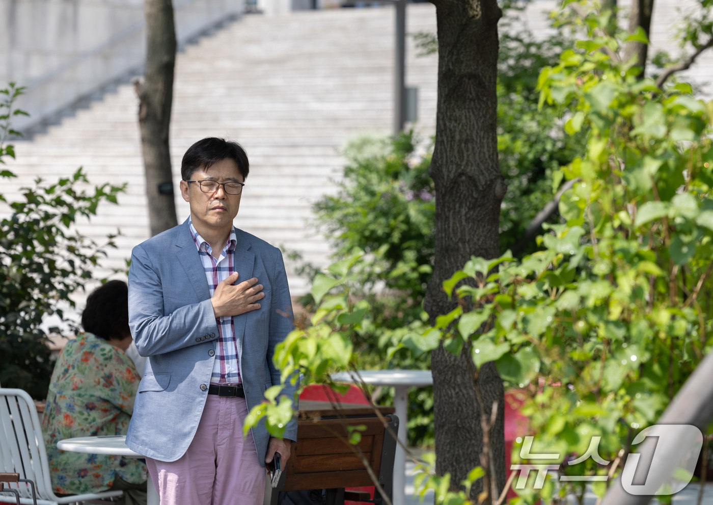 (서울=뉴스1) 이재명 기자 = 현충일인 6일 오전 서울 종로구 광화문 광장에서 한 시민이 사이렌이 울리자 가슴에 손을 얹고 묵념하고 있다.이 시민은 "순국 선열 덕분에 나라가 민 …