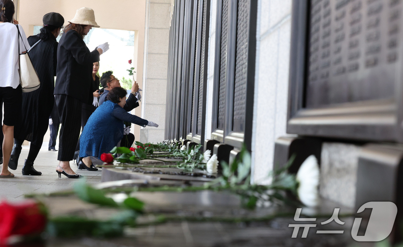 (서울=뉴스1) 신웅수 기자 = 현충일인 6일 서울 용산구 전쟁기념관에서 시민들이 전사자 명비에 헌화하고 있다. 2024.6.6/뉴스1