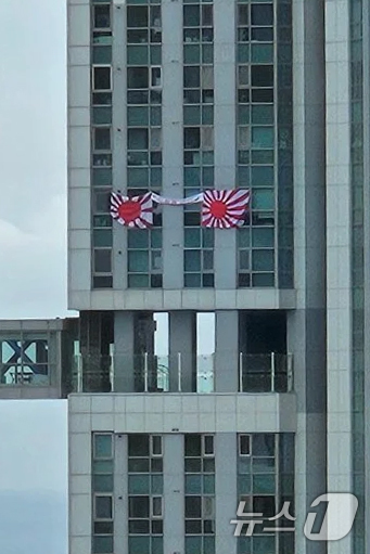 (서울=뉴스1) = 제69회 현충일인 6일 부산시 수영구의 한 주상복합건물 아파트 창문에 일본 국군주의 상징인 욱일기가 내걸려 있다. (온라인커뮤니티 캡쳐)2024.6.6/뉴스1