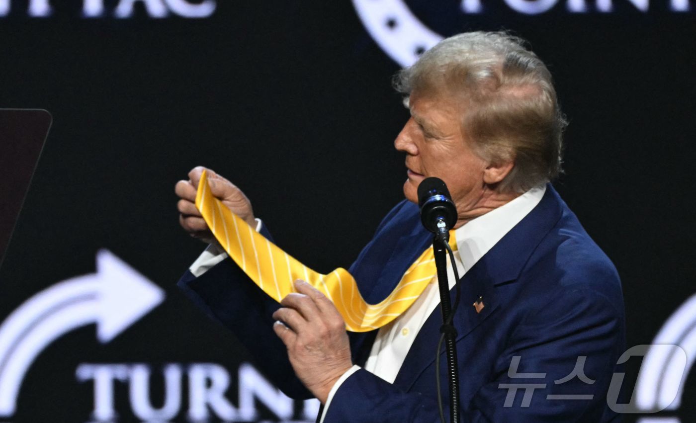 (피닉스 AFP=뉴스1) 우동명 기자 = 도널드 트럼프 전 미국 대통령이 6일(현지시간) 애리조나주 피닉스에서 열린 타운홀 행사에 참석해 넥타이를 들고 연설을 하고 있다. 2024 …