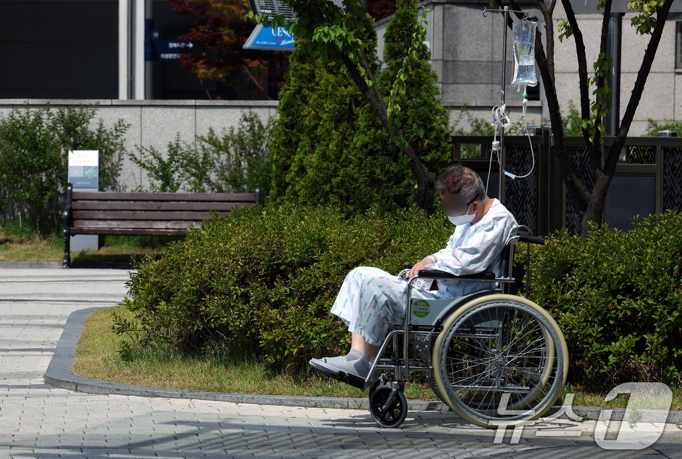 정부의 의대 정원 증원에 반발해 전국 수련병원에 사직서를 제출한 전공의를 비롯해 의료계의 집단행동이 이어지고 있는 9일 서울 시내 한 대학병원에서 휠체어를 탄 환자가 건물 밖에서 시간을 보내고 있다. 2024.6.9/뉴스1 ⓒ News1 박정호 기자