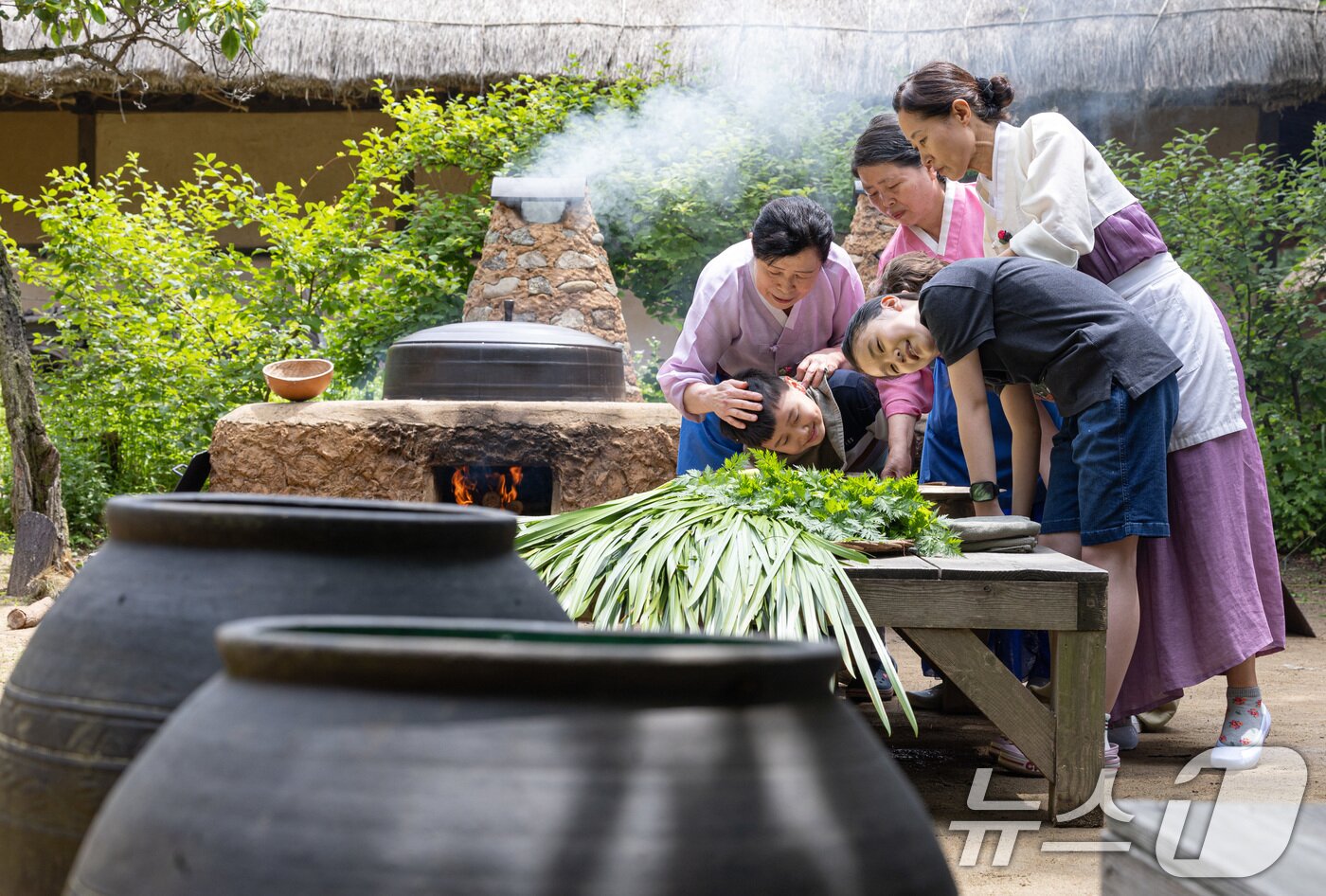본문 이미지 - 단오(음력 5월5일)를 하루 앞둔 9일 경기도 용인시 기흥구 한국민속촌에서 어린이들이 창포물에 머리 감기 체험을 하고 있다. 2024.6.9/뉴스1 ⓒ News1 이재명 기자