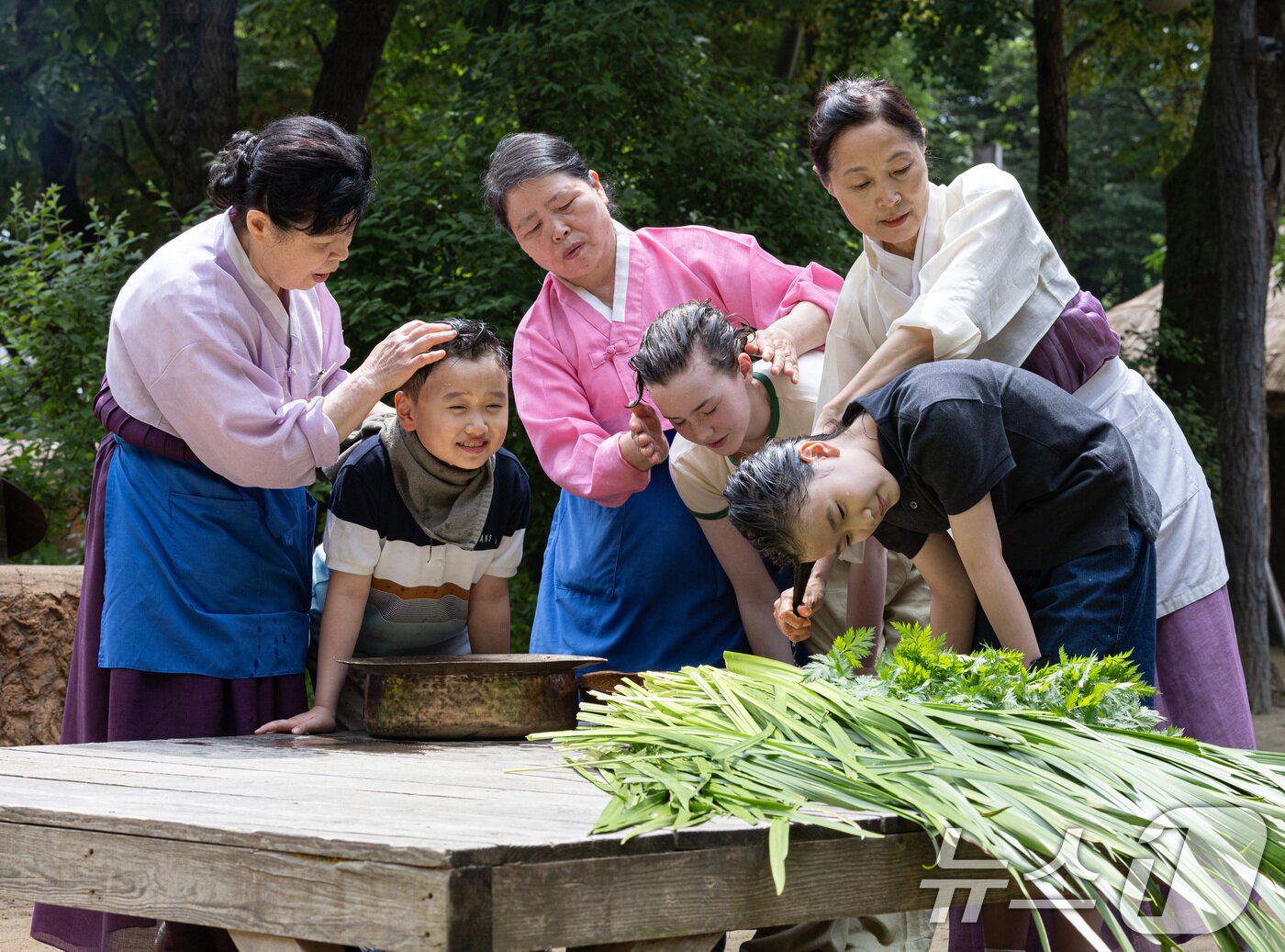 본문 이미지 - 단오(음력 5월5일)를 하루 앞둔 9일 경기도 용인시 기흥구 한국민속촌에서 어린이들이 창포물에 머리 감기 체험을 하고 있다. 2024.6.9/뉴스1 ⓒ News1 이재명 기자