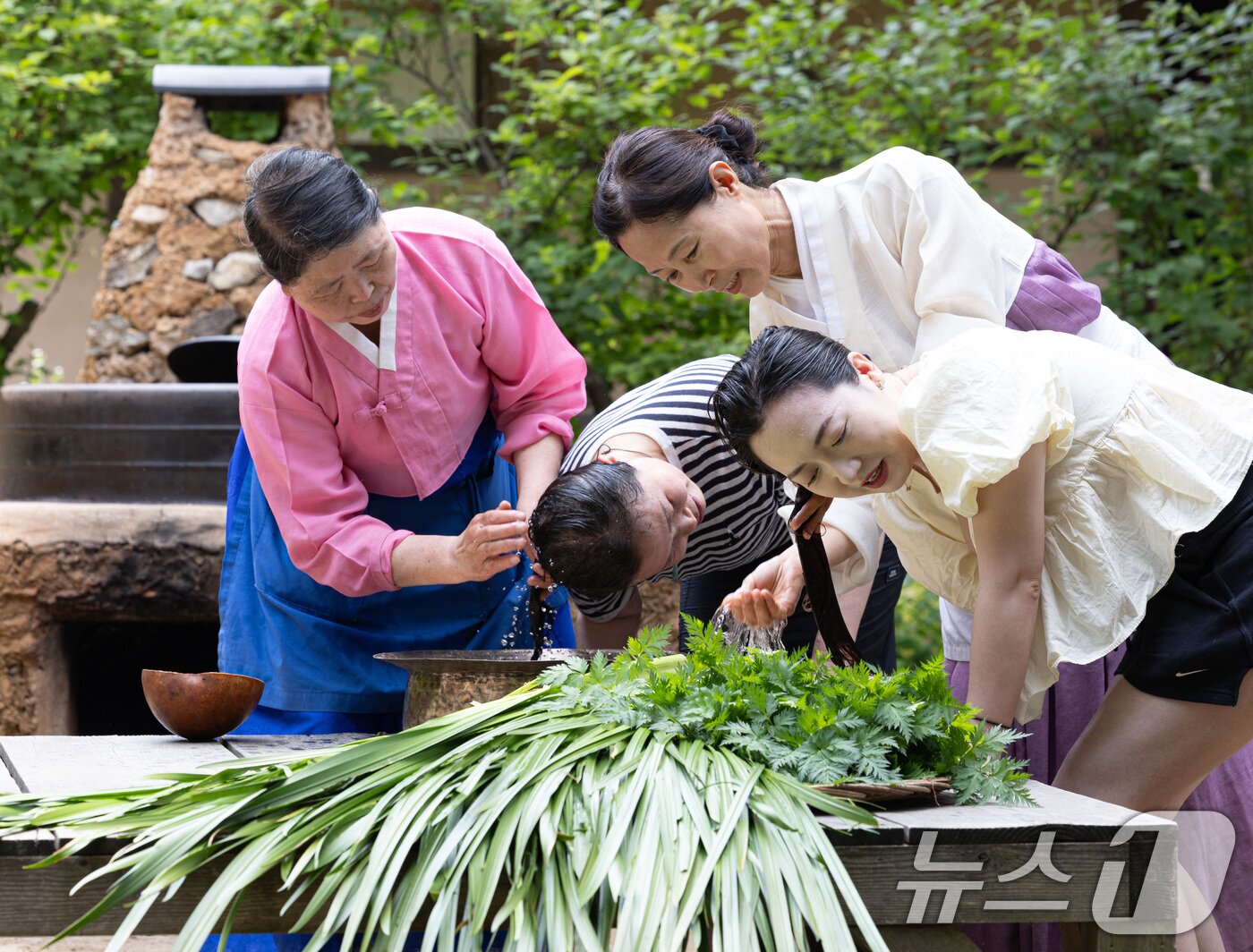 본문 이미지 - 단오(음력 5월5일)를 하루 앞둔 9일 경기도 용인시 기흥구 한국민속촌에서 외국인 관광객들이 창포물에 머리 감기 체험을 하고 있다. 2024.6.9/뉴스1 ⓒ News1 이재명 기자