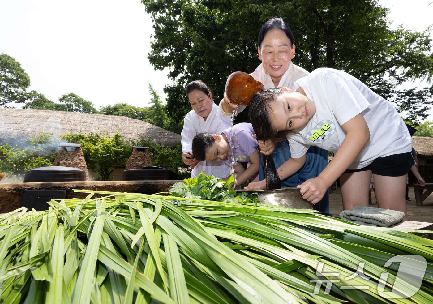 본문 이미지 - 단오(음력 5월5일)를 하루 앞둔 9일 경기도 용인시 기흥구 한국민속촌에서 어린이들이 창포물에 머리 감기 체험을 하고 있다. 2024.6.9/뉴스1 ⓒ News1 이재명 기자
