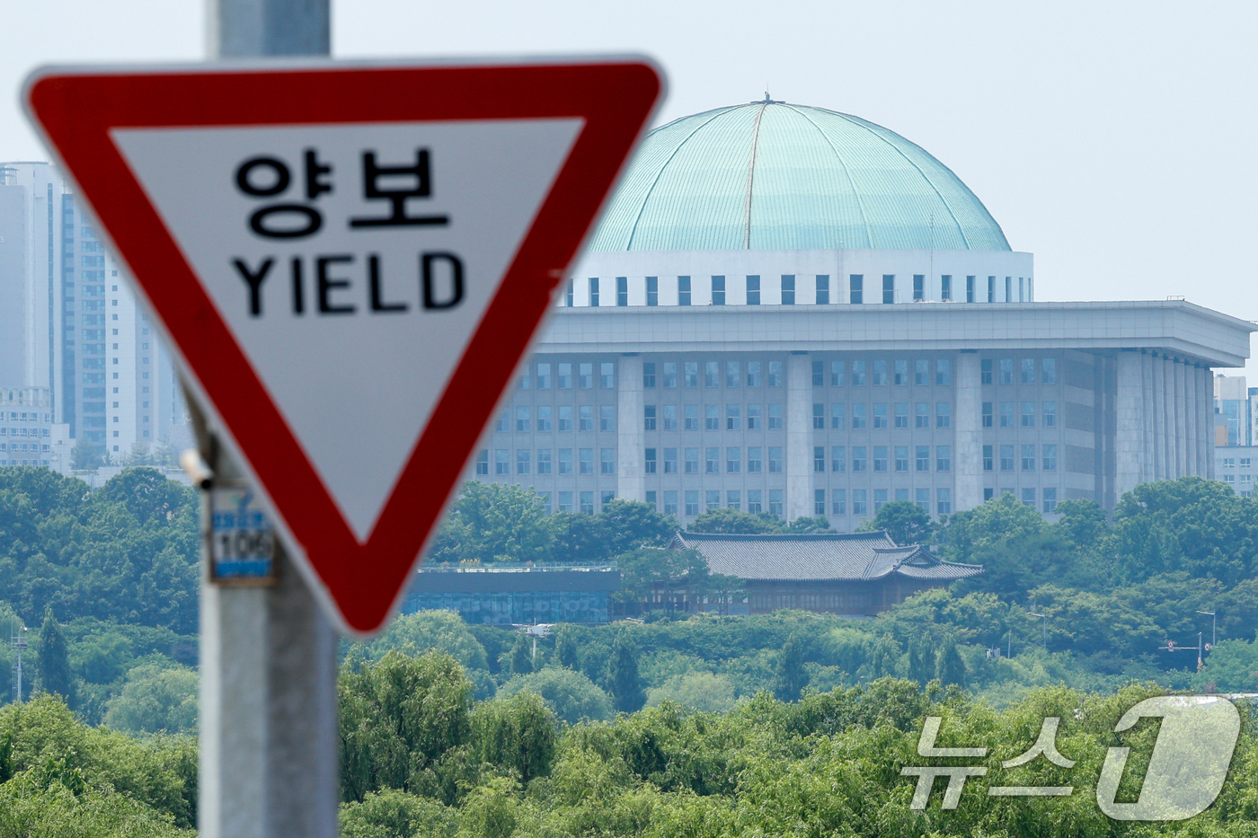 (서울=뉴스1) 안은나 기자 = 여야가 원구성 협상의 합의점을 찾지 못하고 있는 9일 서울 서강대교에 있는 양보 교통표지판 뒤로 국회의사당이 보이고 있다.더불어민주당은 이날까지 합 …