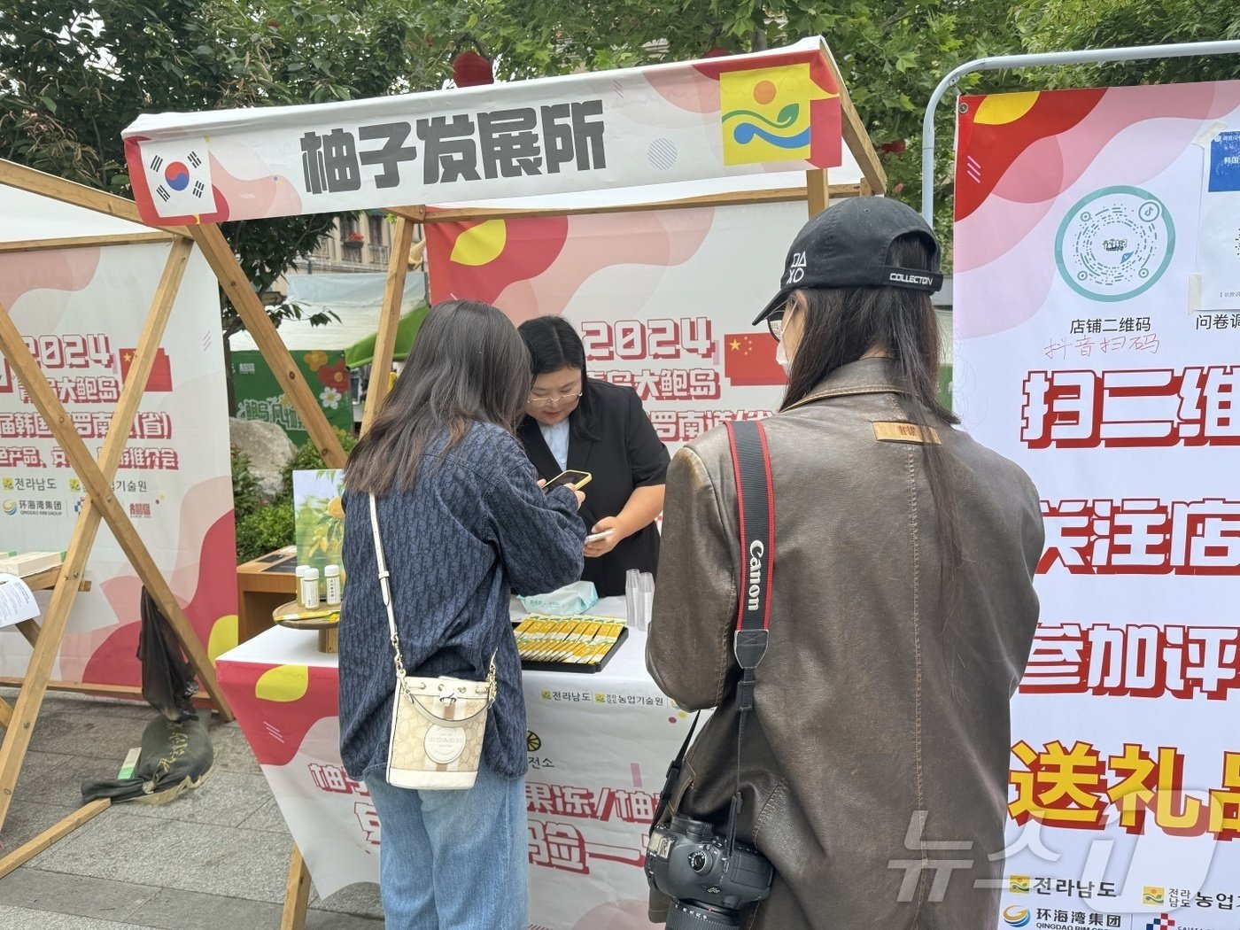 오진영 전남 완도 유자발전소 대표&#40;가운데&#41;가 지난 5월 중국 청도에서 열린 전남 농식품 현지 판촉 행사에서 현지인들에 유자 음료 ‘유자블라썸’을 선보이고 있다.&#40;유자발전소 제공&#41;2024.6.9./뉴스1