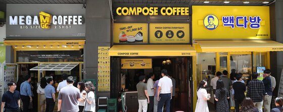 본문 이미지 - 서울 시내에 위치한 저가 브랜드 커피 매장 앞에서 시민들이 줄지어 커피를 구매하고 있다. 2024.7.1 / ⓒ 뉴스1 임세영 기자