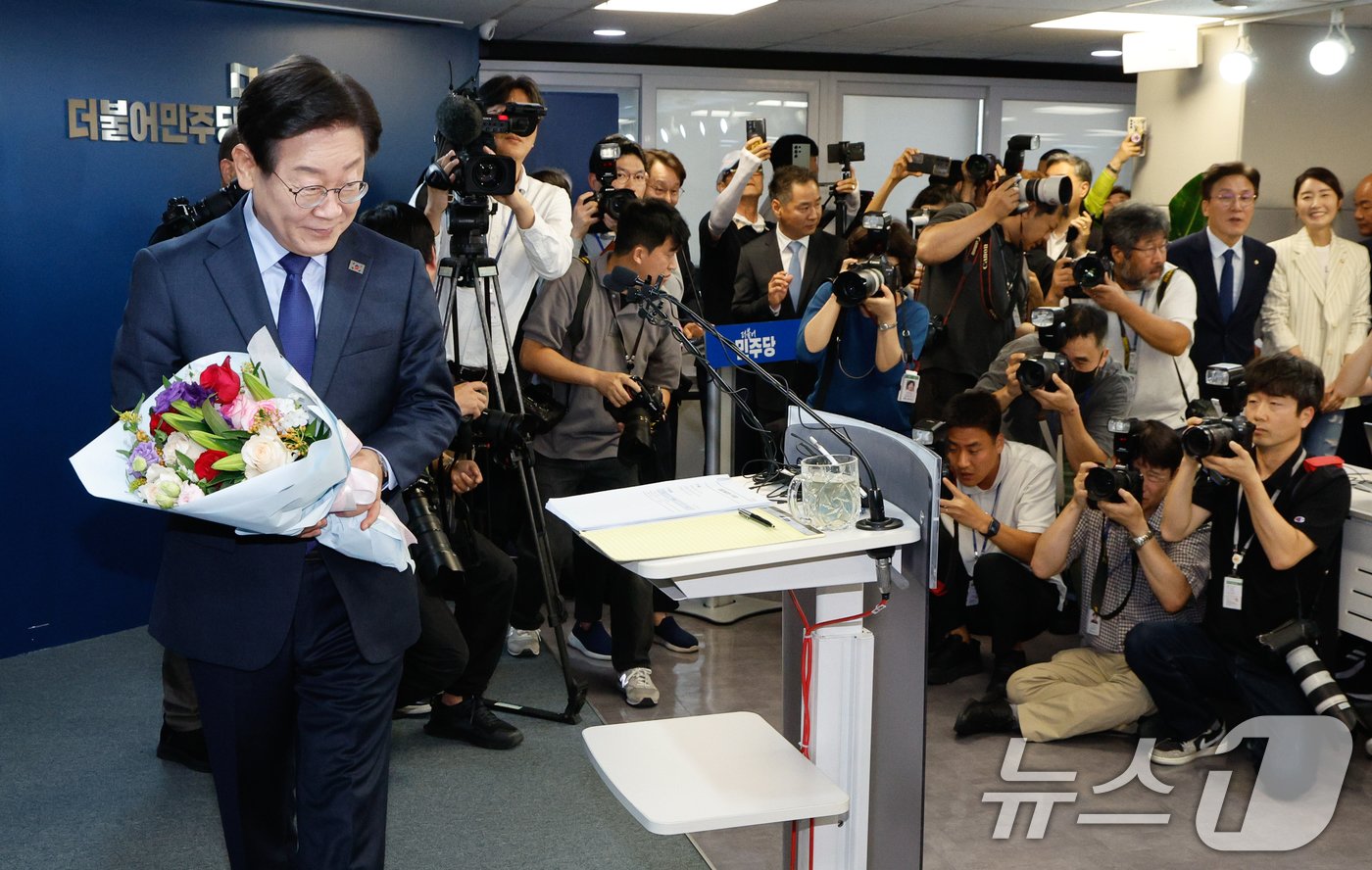 본문 이미지 - 이재명 더불어민주당 전 대표가 10일 서울 여의도 당사에서 8·18 전당대회 당 대표 출마를 선언하기 전 지지자로부터 받은 꽃다발을 들고 있다. 2024.7.10/뉴스1 ⓒ News1 안은나 기자