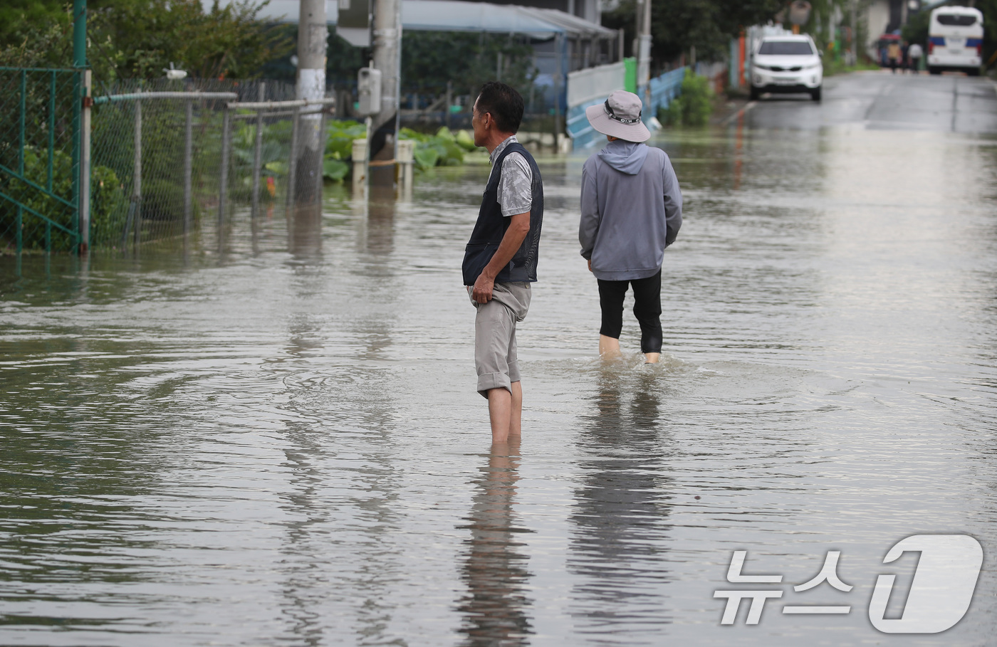 (대구=뉴스1) 공정식 기자 = 집중호우가 쏟아진 10일 대구 동구 금호강 일부 구간이 범람해 금강동 진입로가 침수되자 주민들이 거대한 물웅덩이를 건너고 있다. 2024.7.10/ …