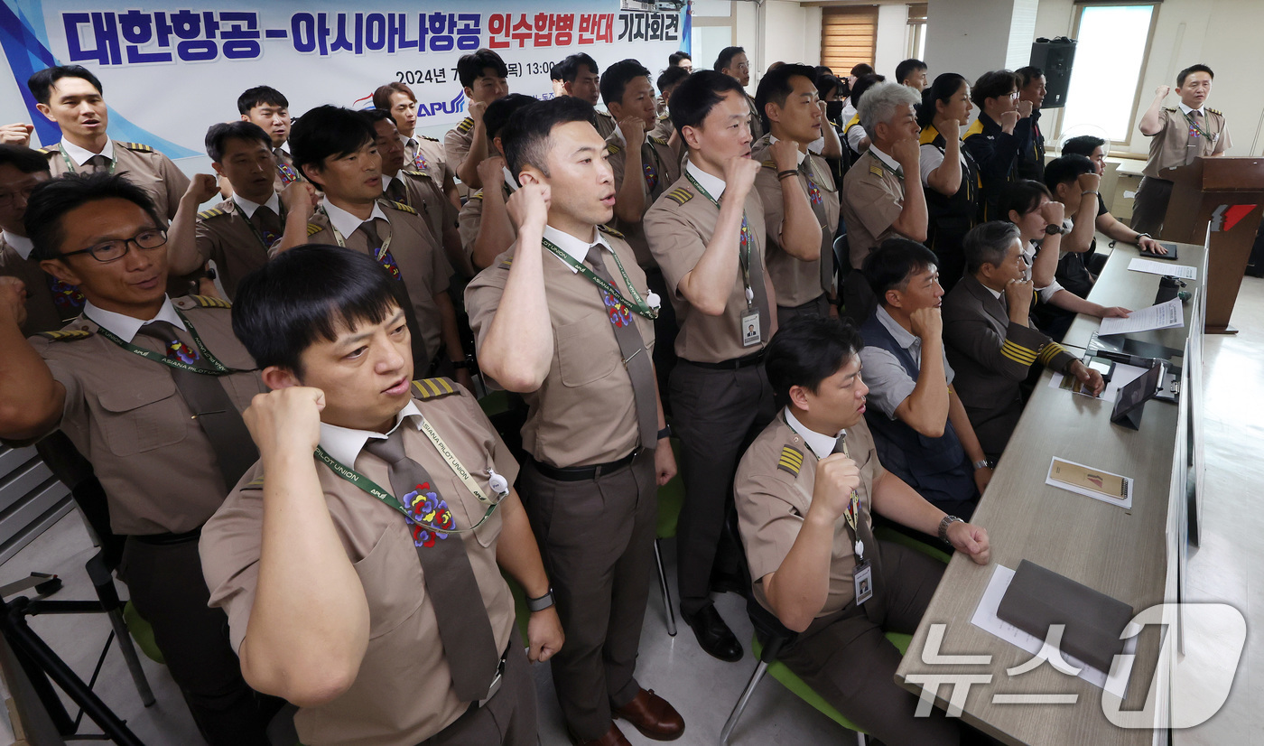 (서울=뉴스1) 이동해 기자 = 아시아나 항공조종사노동조합과 항공노동조합원들이 11일 오후 서울 중구 민주노총에서 열린 대한항공-아시아나항공 인수합병 반대 기자회견에서 구호를 외치 …