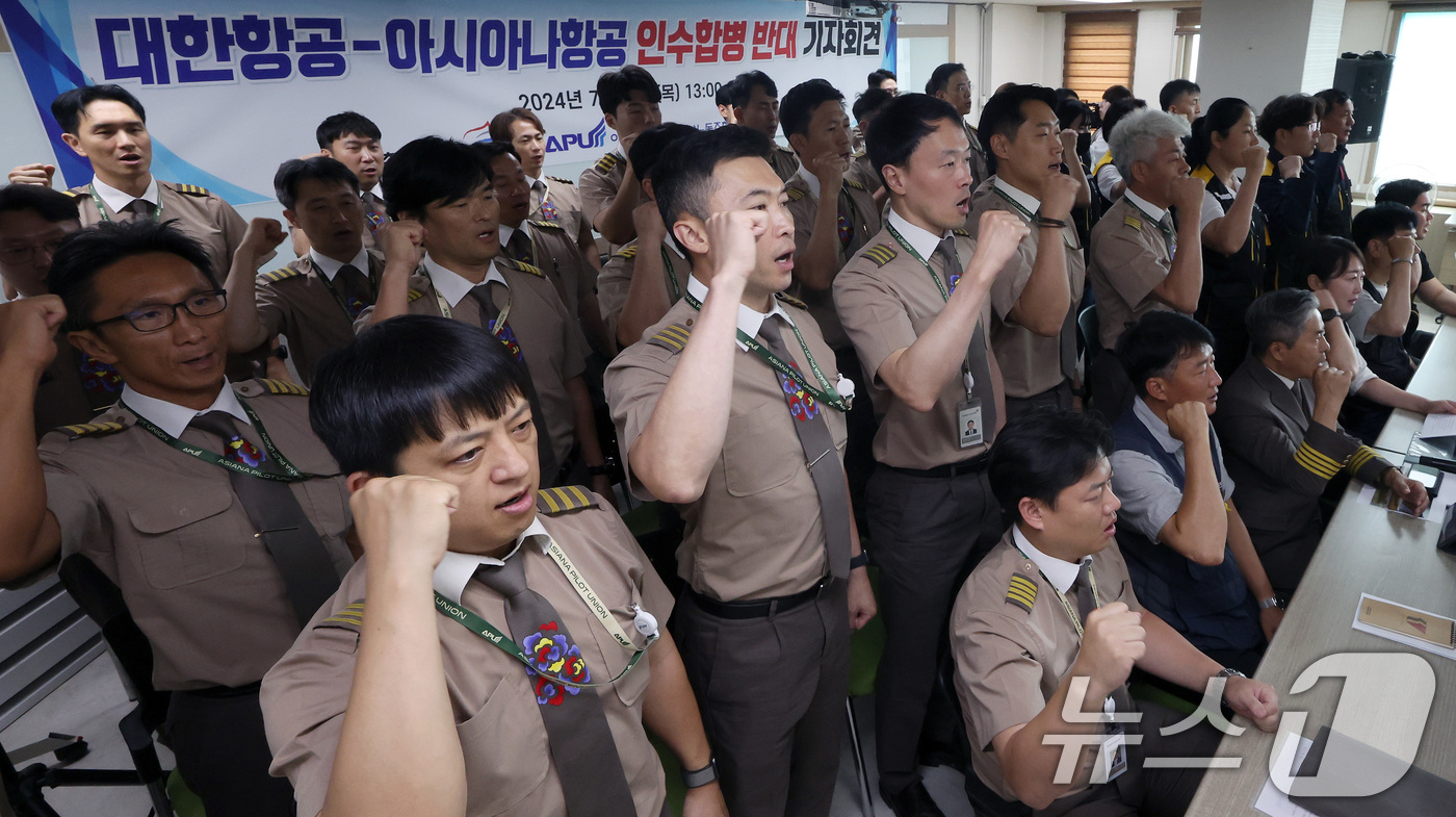 (서울=뉴스1) 이동해 기자 = 아시아나 항공조종사노동조합과 항공노동조합원들이 11일 오후 서울 중구 민주노총에서 열린 대한항공-아시아나항공 인수합병 반대 기자회견에서 구호를 외치 …