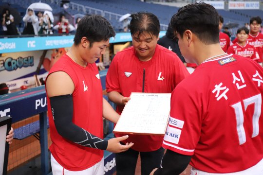 본문 이미지 - 시라카와(맨 왼쪽)가 SSG와 작별하기 전 첫 등판 라인업지를 선물로 받고 있다. 가운데가 금강산 파트너. (SSG 랜더스 제공)
