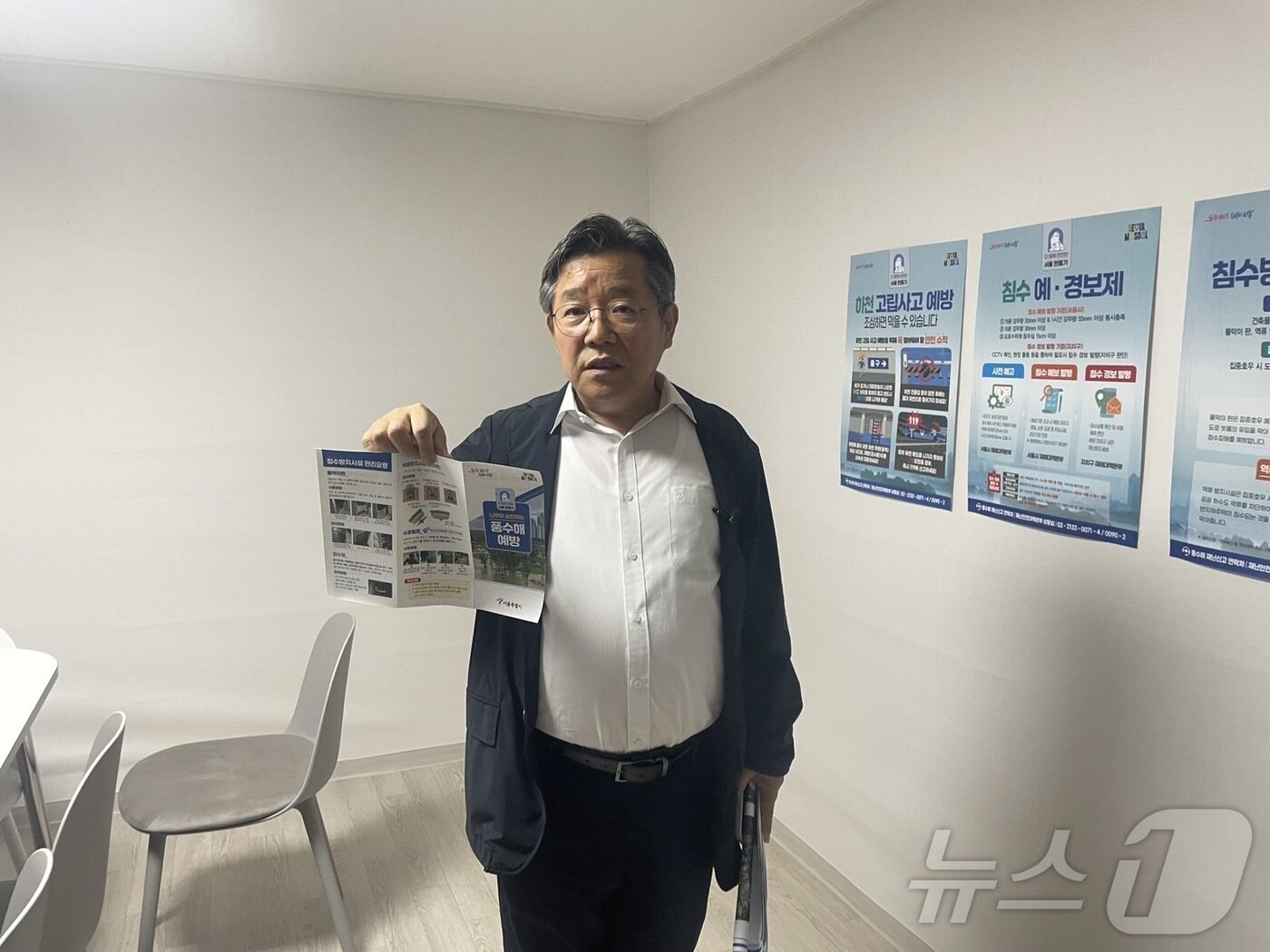 본문 이미지 - 김헌동 SH공사 사장이 12일 오전 서울시 관악구 신림동에 위치한 &#39;동네 수방 거점&#39;에서 취재진을 만나고 있다. 옆으로 책상과 의자, 재난 대응 관련 포스터가 보인다. 2024.7.12/뉴스1
