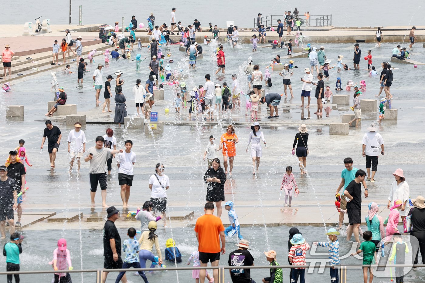본문 이미지 - 낮 최고기온이 33도까지 올라 무더운 날씨를 보인 13일 서울 영등포구 여의도 한강공원 물빛광장에서 어린이와 시민들이 물놀이를 하며 더위를 식히고 있다. 2024.7.13/뉴스1 ⓒ News1 민경석 기자