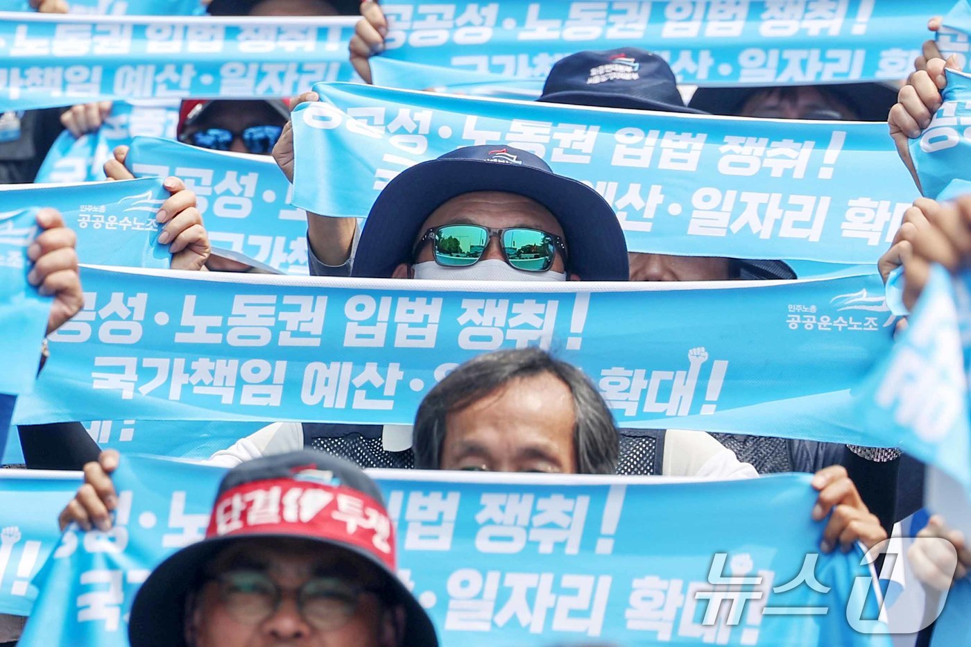 (서울=뉴스1) 민경석 기자 = 민주노총 공공운수노조 조합원들이 13일 오후 서울 영등포구 여의도 국회의사당 앞에서 열린 '7·13 공공운수노조 결의대회'에서 구호를 외치고 있다. …