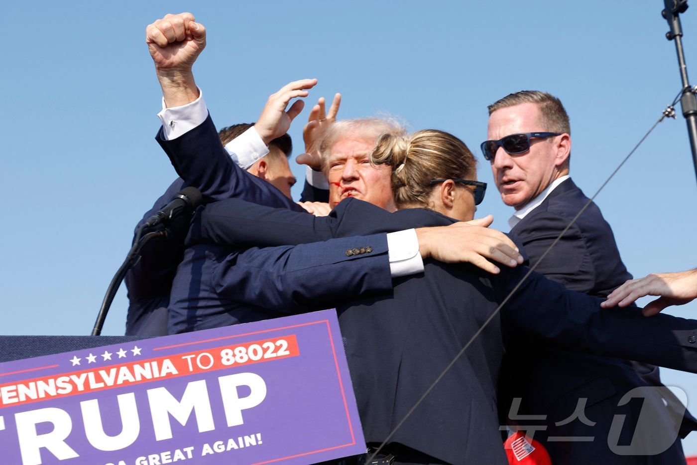 본문 이미지 - 미국 공화당의 대선 후보인 도널드 트럼프 전 대통령이 13일(현지시간) 펜실베이니아 버틀러에서 유세 도중 총격 사건이 발생하자 경호원들에 둘러싸여 서둘러 무대에서 내려오고 있다. ⓒ AFP=뉴스1 ⓒ News1 이동원 기자
