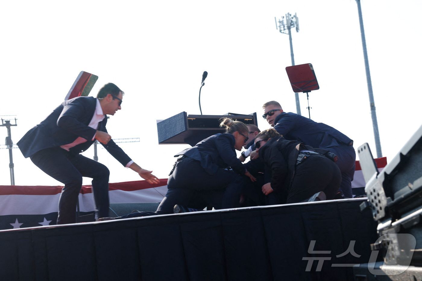 본문 이미지 - 총격 사건 발생 직후 경호원들이 트럼프 후보를  바닥에 엎드리게 하고 있다.  AFP=뉴스1 ⓒ News1 박형기 기자