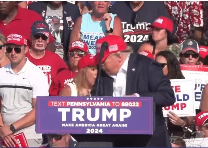 본문 이미지 -  저격범이 쏜 총에 오른쪽 귀를 맞은 트럼프 대통령이 본능적으로 몸을 움츠리고 있다. (페이스북 갈무리) ⓒ 뉴스1