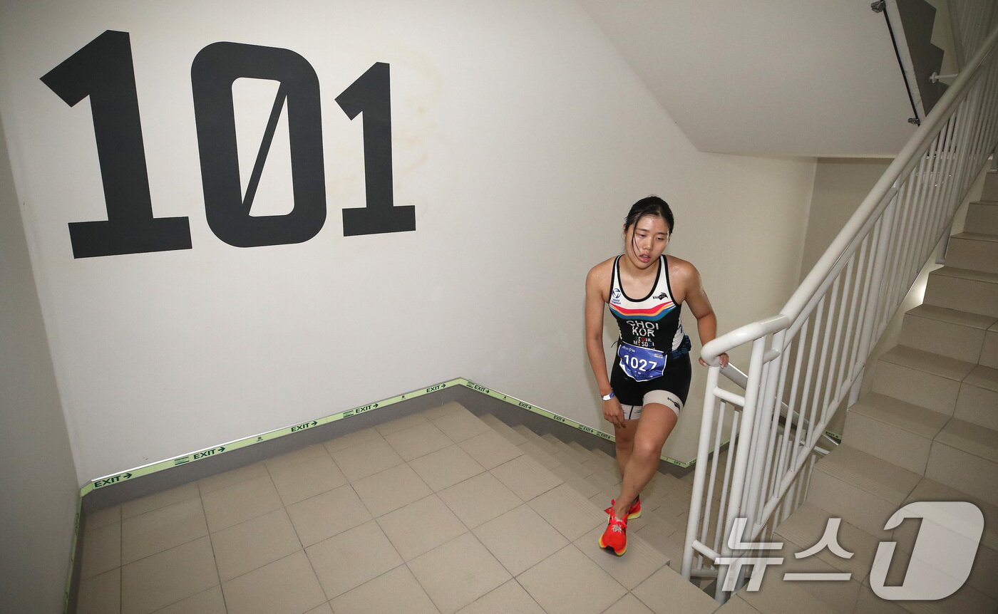 본문 이미지 - 14일 오전 서울 송파구 롯데월드타워 일대에서 열린 '2024 롯데 아쿠아슬론'에서 석촌호수 수영을 마친 참가자가 롯데월드타워 계단을 오르고 있다. 2024.7.14/뉴스1 ⓒ News1 임세영 기자