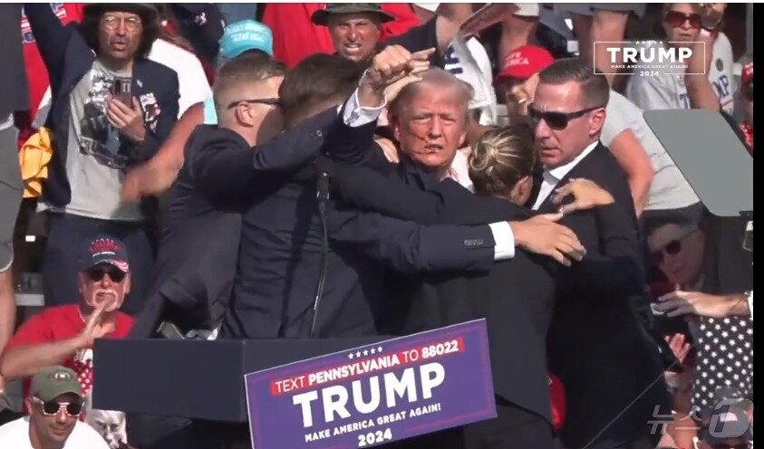 본문 이미지 -  저격범이 쏜 총에 오른쪽 귀를 다친 도널드 트럼프 전 미국대통령이 피를 흘리면서 '나는 이긴다, 무사하다'며 주멱을 쥐어 보이고 있다. (페이스북 갈무리) ⓒ 뉴스1 