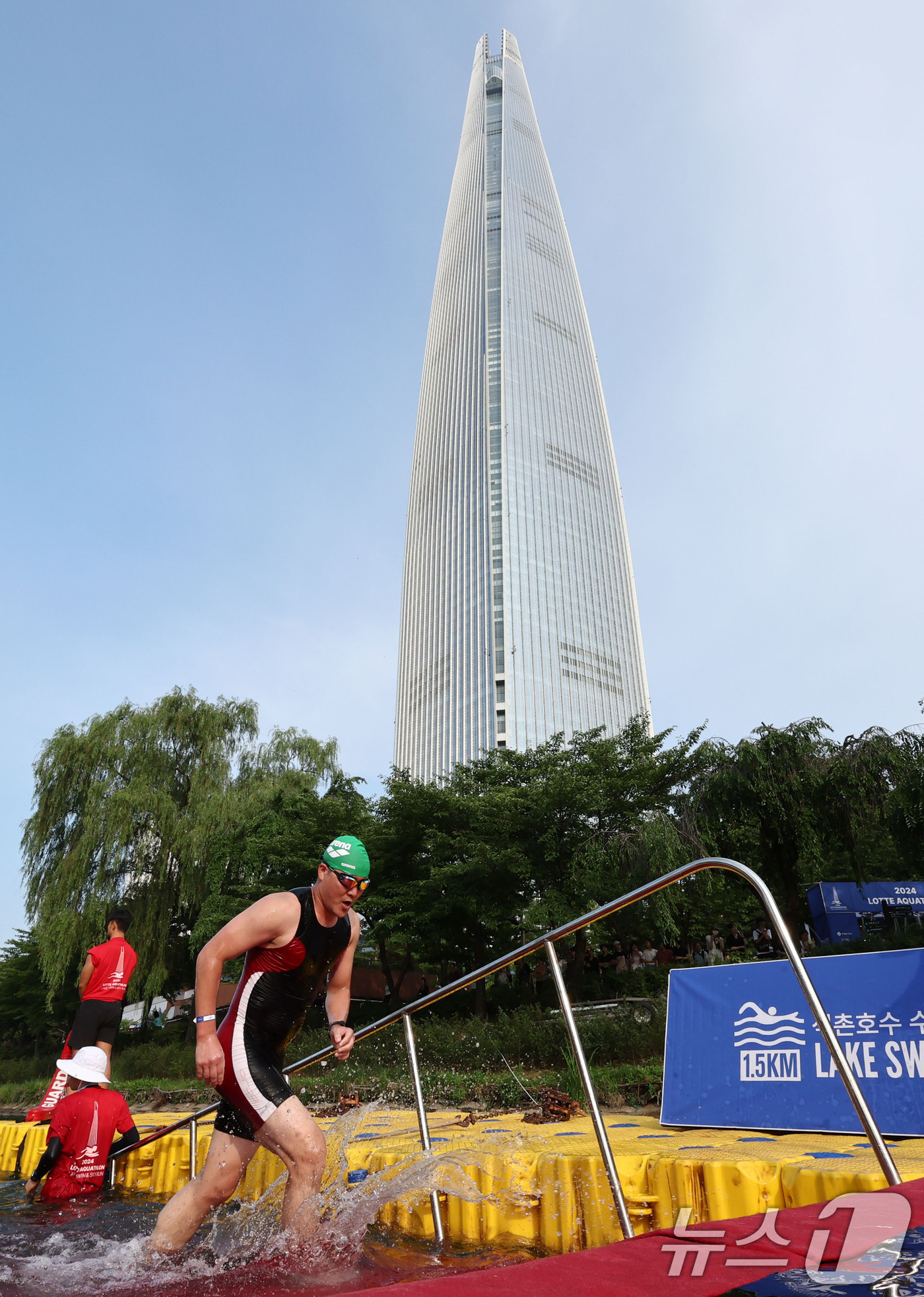 (서울=뉴스1) 임세영 기자 = 14일 오전 서울 송파구 롯데월드타워 일대에서 열린 '2024 롯데 아쿠아슬론'에 출전한 참가자들이 석촌호수에서 수영을 마치고 있다.철인 3종 경기 …