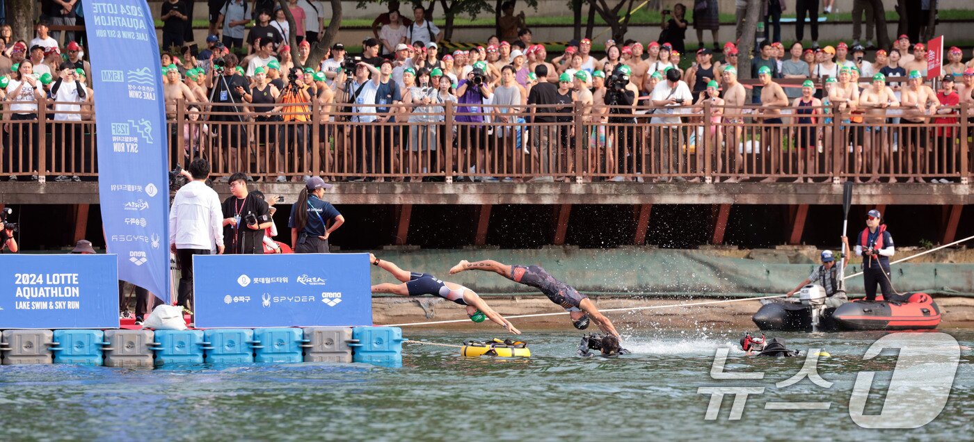 본문 이미지 - 14일 오전 서울 송파구 롯데월드타워 일대에서 열린 '2024 롯데 아쿠아슬론'에 출전한 참가자들이 석촌호수에서 수영을 하고 있다.  (공동취재) 2024.7.14/뉴스1 ⓒ News1 임세영 기자