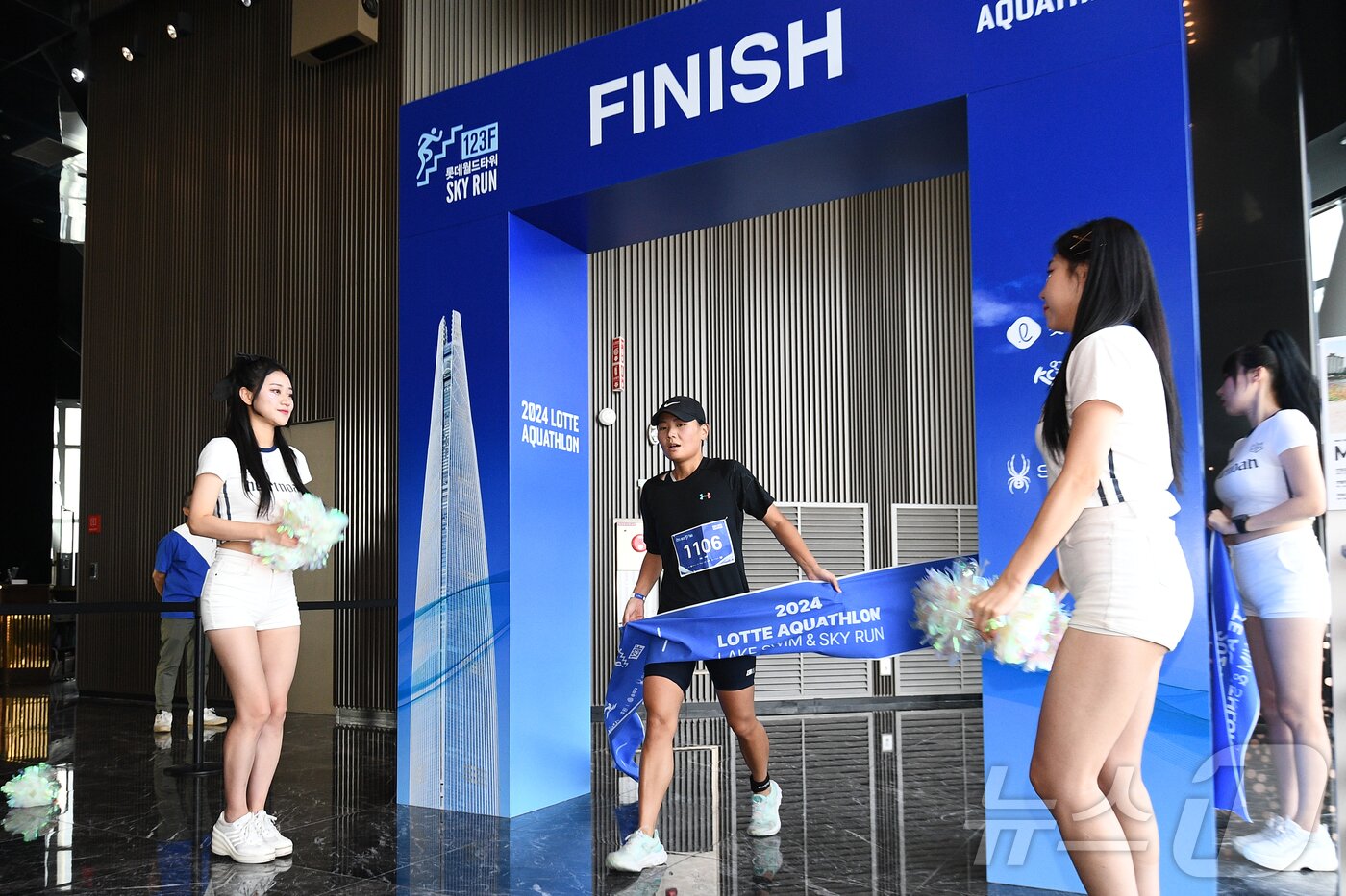 본문 이미지 - 14일 오전 서울 송파구 롯데월드타워 일대에서 열린 '2024 롯데 아쿠아슬론'에서 석촌호수 수영을 마친 참가자가 타워 123층 결승점을 통과하고 있다. (공동취재) 2024.7.14/뉴스1 ⓒ News1 임세영 기자