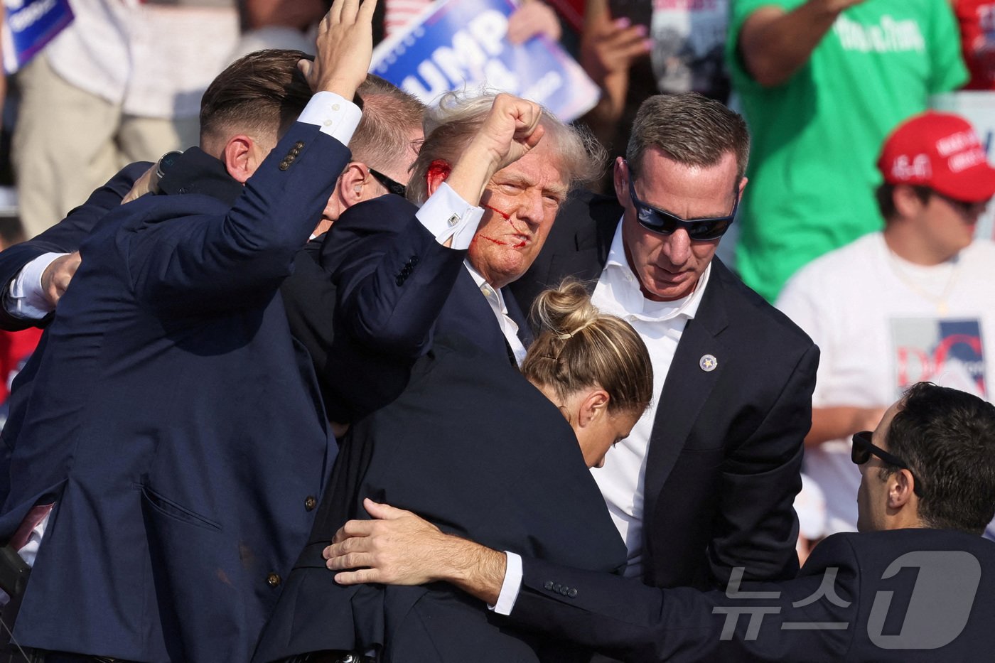 본문 이미지 - 경호원들과 함께 연단을 내려가면서도 주먹을 불끈 쥐고 있는 트럼프. ⓒ 로이터=뉴스1 ⓒ News1 이종덕 기자