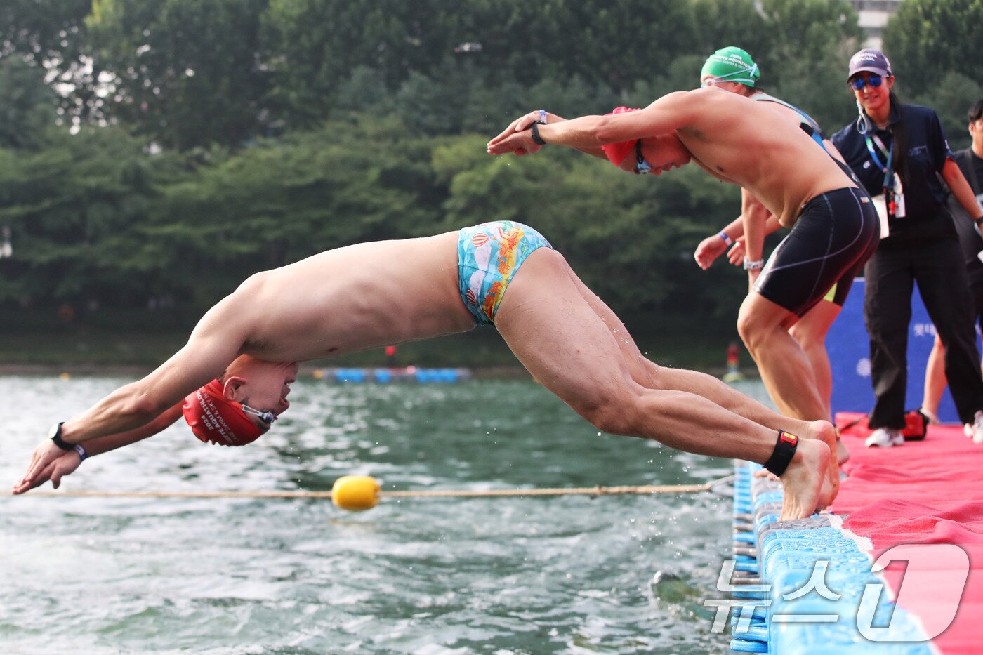 본문 이미지 - 14일 오전 서울 송파구 롯데월드타워 일대에서 열린 '2024 롯데 아쿠아슬론'에 출전한 참가자들이 석촌호수로 뛰어들고 있다.  (공동취재) 2024.7.14/뉴스1 ⓒ News1 임세영 기자
