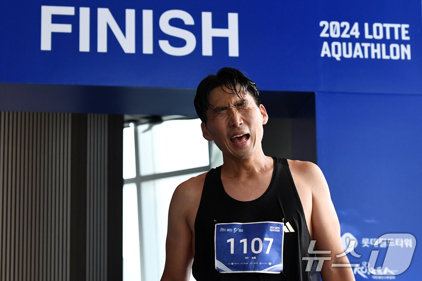 본문 이미지 - 14일 오전 서울 송파구 롯데월드타워 일대에서 열린 '2024 롯데 아쿠아슬론'에서 석촌호수 수영을 마친 참가자가 타워 123층 결승선을 통과하고 있다. (공동취재) 2024.7.14/뉴스1 ⓒ News1 임세영 기자